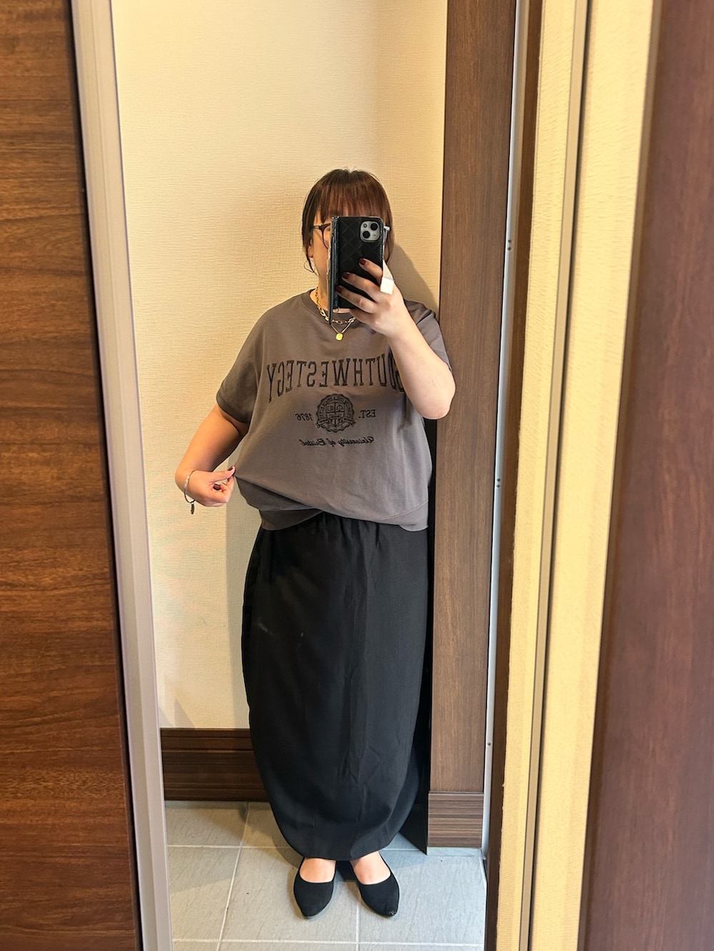グレー系のTシャツ/カットソー、ブラック系のスカート、ブラック系のバッグを着用したレディースの夏コーディネートの2枚目の写真