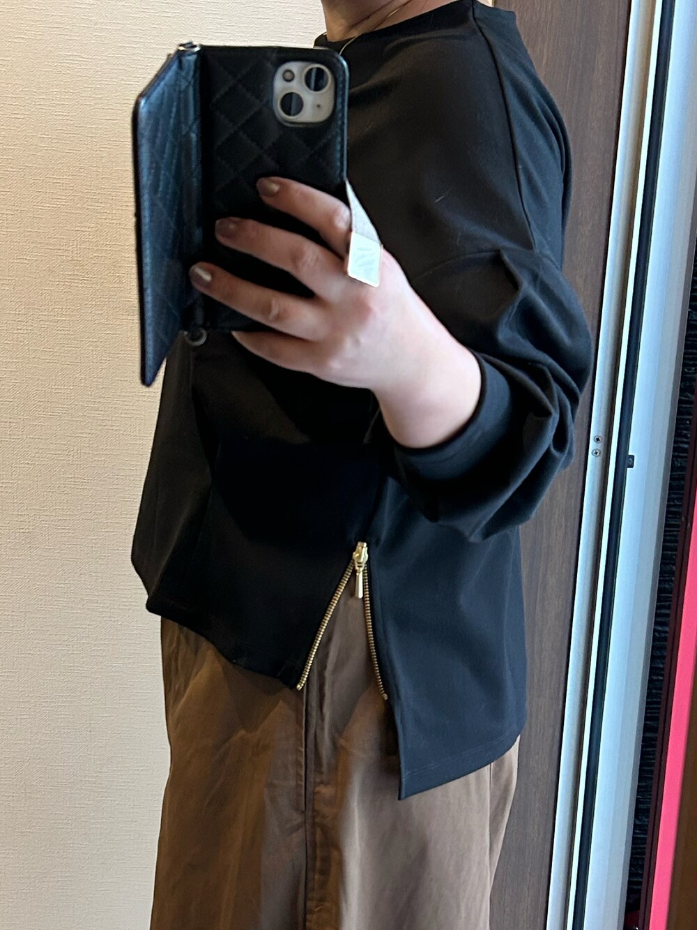 ブラック系のTシャツ/カットソー、ブラウン系のパンツ、ブラック系のバッグを着用したレディースの秋コーディネートの3枚目の写真