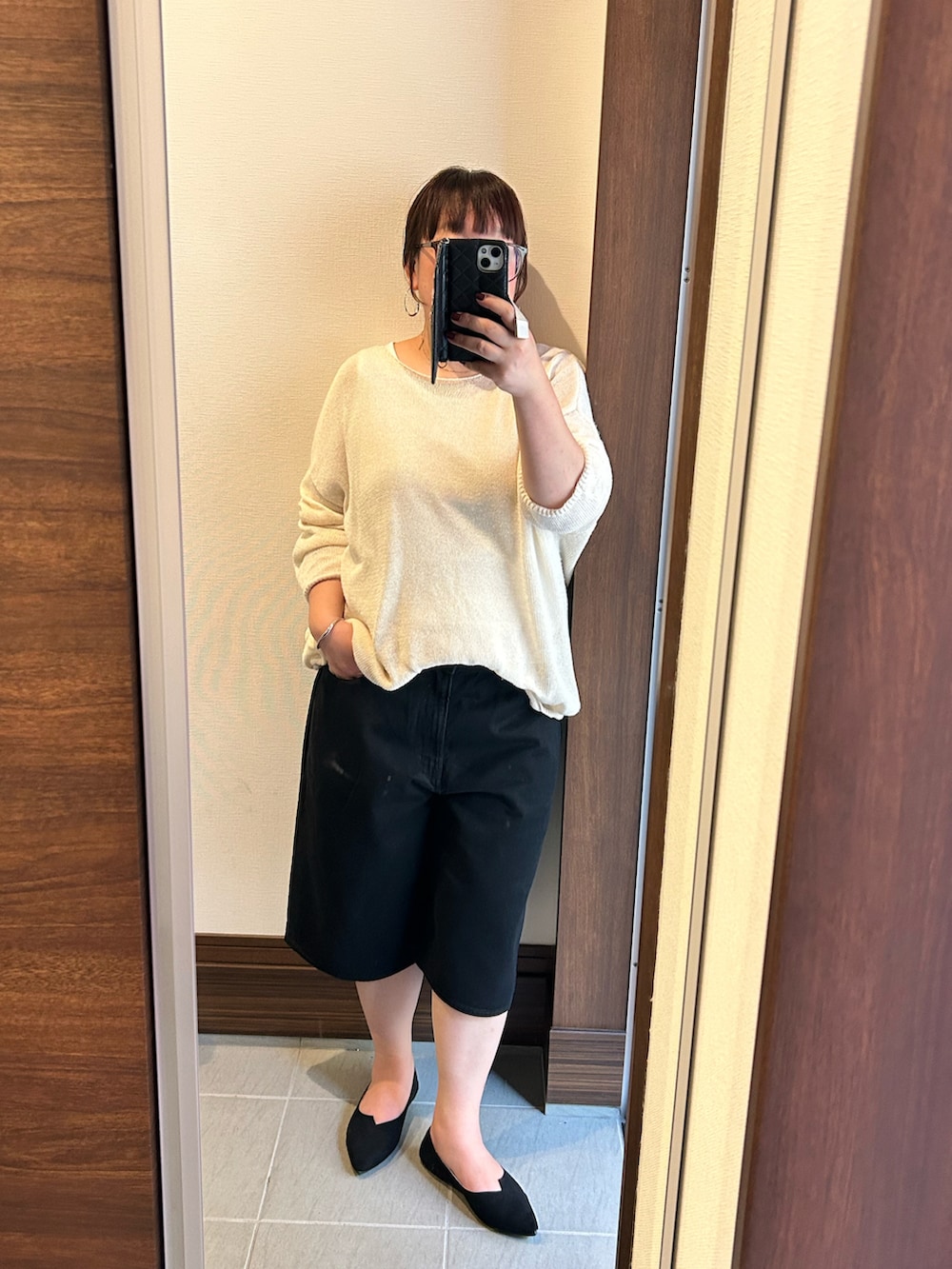 ホワイト系のニット/セーター、ブラック系のパンツ、ブラック系のバッグを着用したレディースの夏コーディネートの2枚目の写真