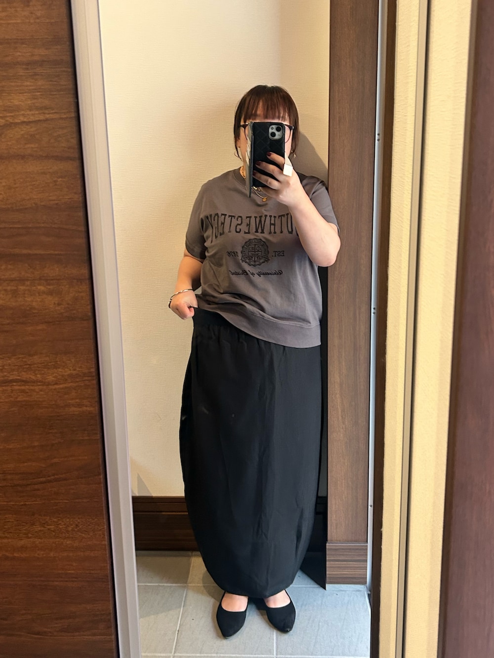 グレー系のTシャツ/カットソー、ブラック系のスカート、ブラック系のバッグを着用したレディースの夏コーディネートの3枚目の写真