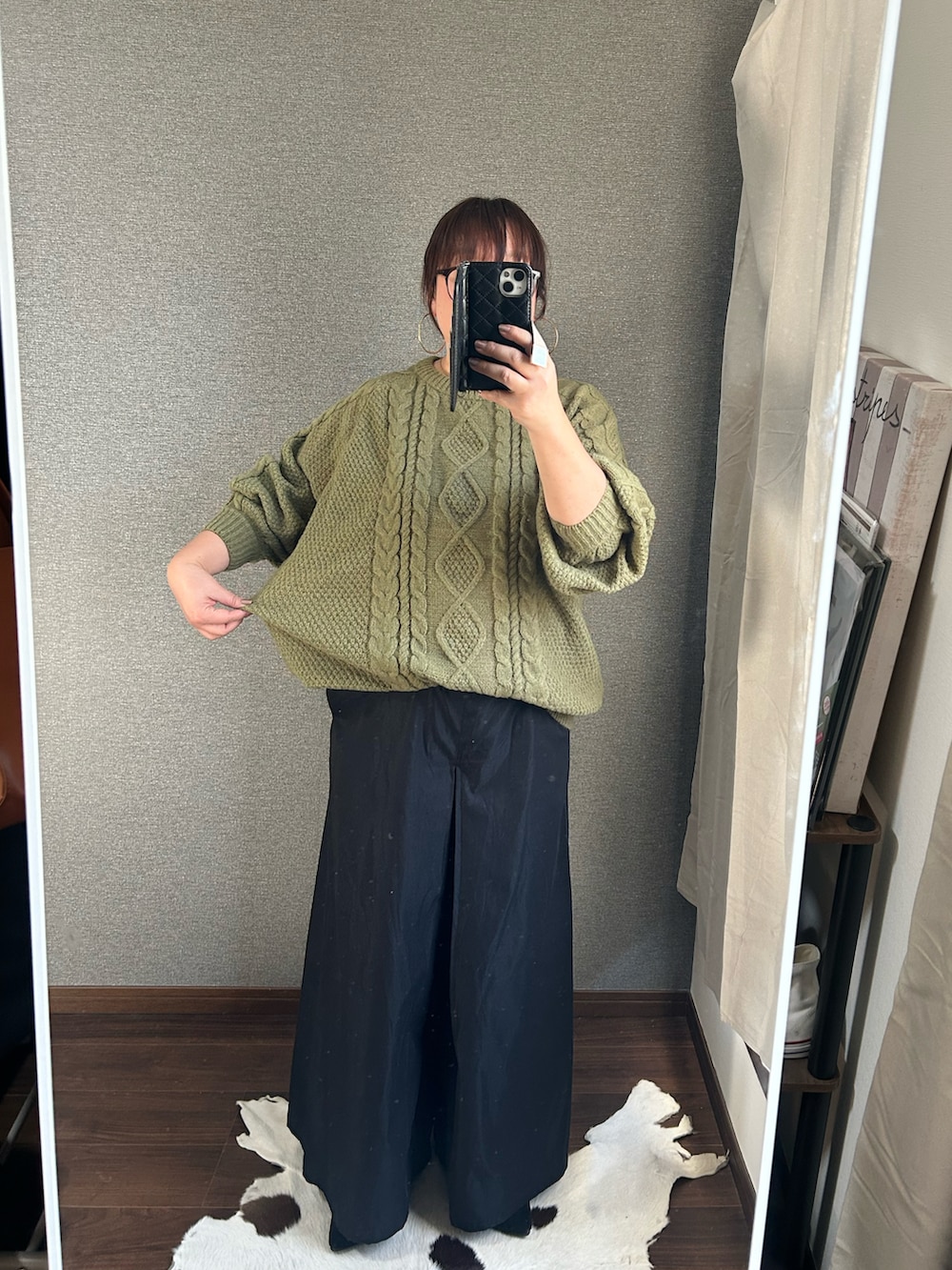 グリーン系のニット/セーター、ブラック系のパンツ、ブラック系のバッグを着用したレディースの冬コーディネートの2枚目の写真