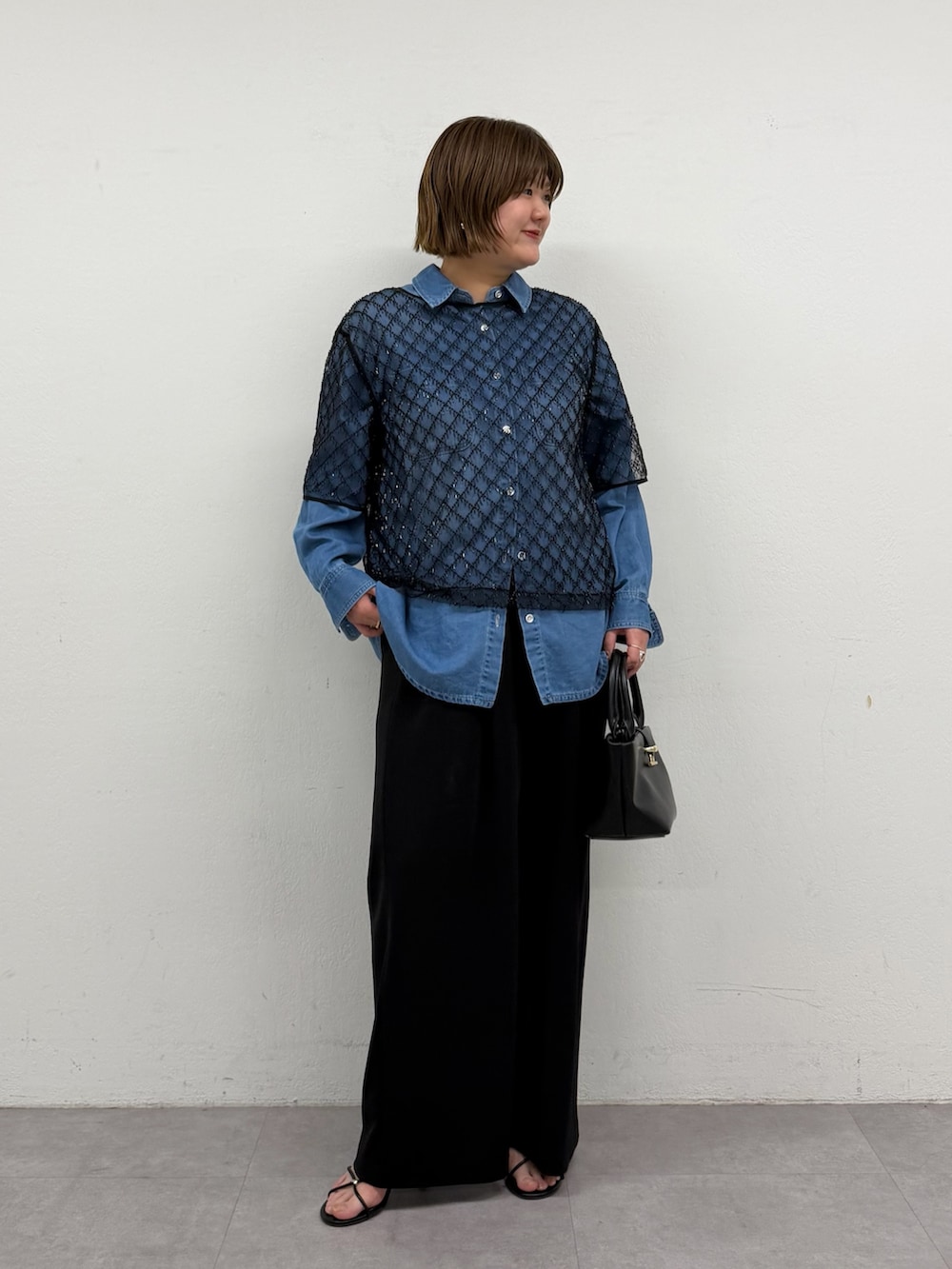 ブラック系のシャツ/ブラウス、ブルー系のシャツ/ブラウス、ブラック系のハンドバッグを着用したレディースの春コーディネートの2枚目の写真
