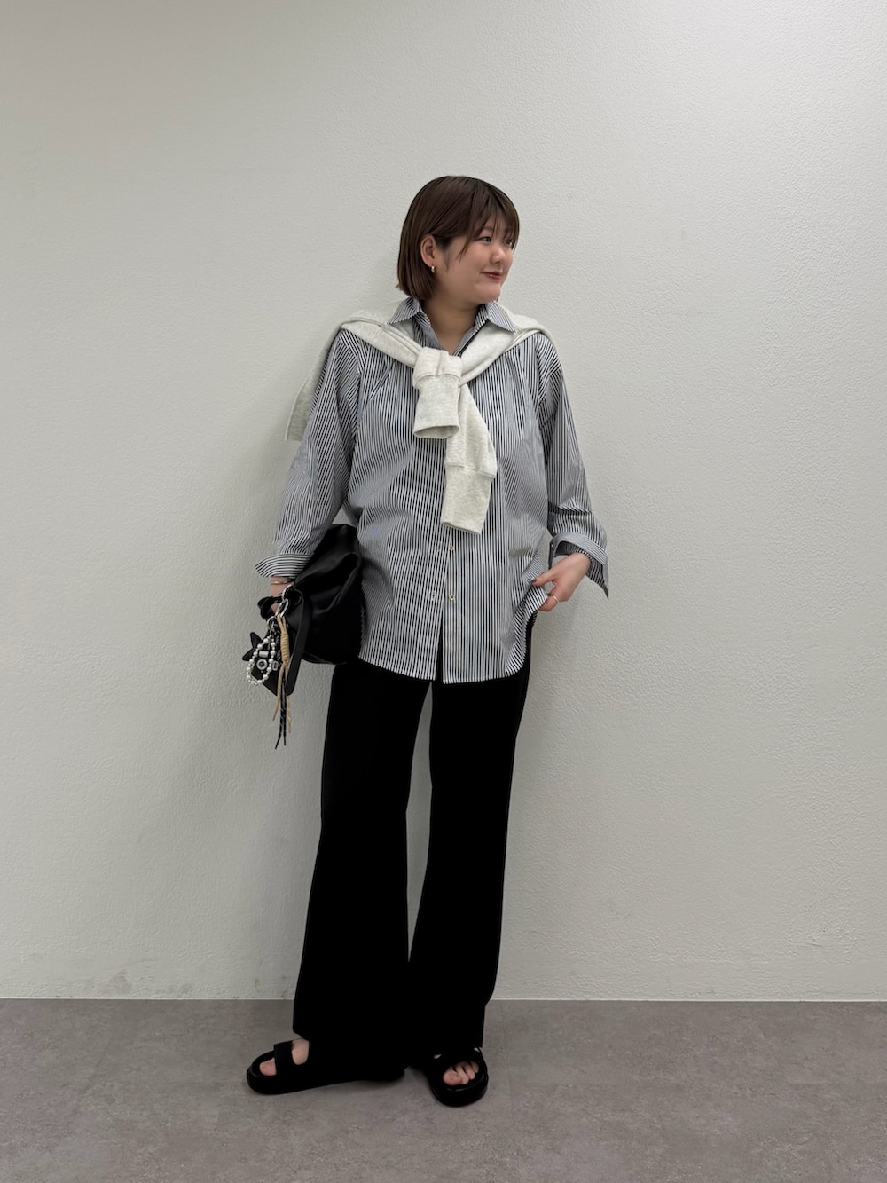 グレー系のスウェット、ブルー系のシャツ/ブラウス、ブラック系のトートバッグを着用したレディースの春コーディネートの2枚目の写真