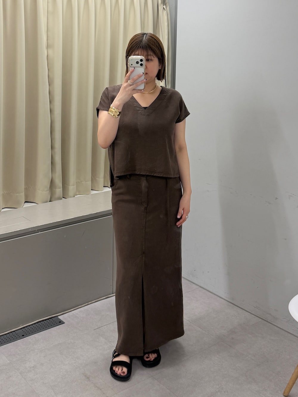 ブラウン系のシャツ/ブラウス、ブラウン系のスカート、ブラック系のサンダルを着用したレディースの夏コーディネートの2枚目の写真