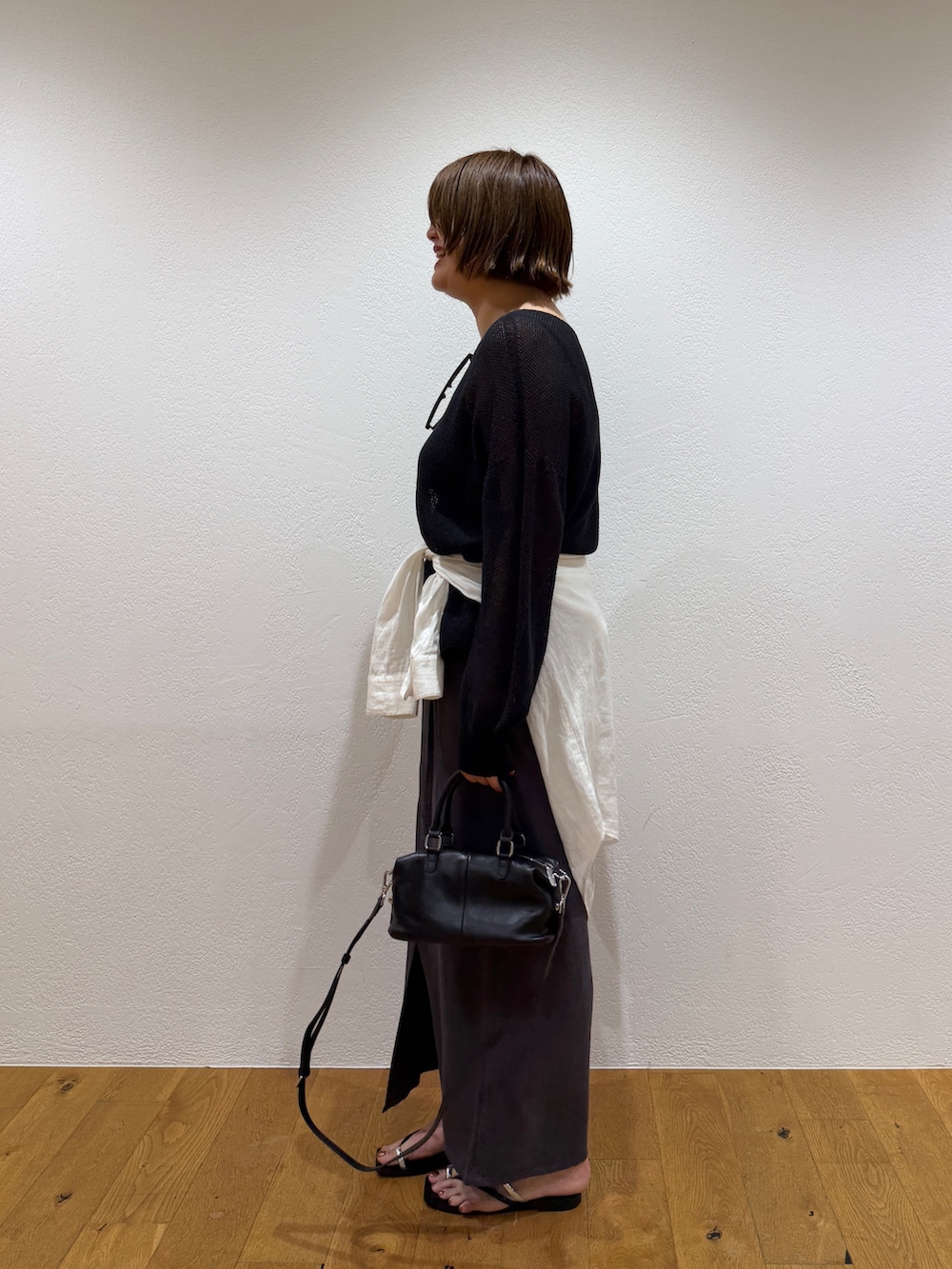 ブラック系のニット/セーター、ホワイト系のシャツ/ブラウス、グレー系のスカートを着用したレディースの夏コーディネートの3枚目の写真