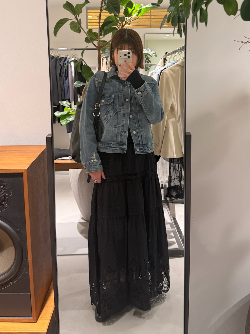 ブルー系のデニムジャケット、ブラック系のスカート、ブラック系のトートバッグを着用したレディースの春コーディネートの2枚目の写真