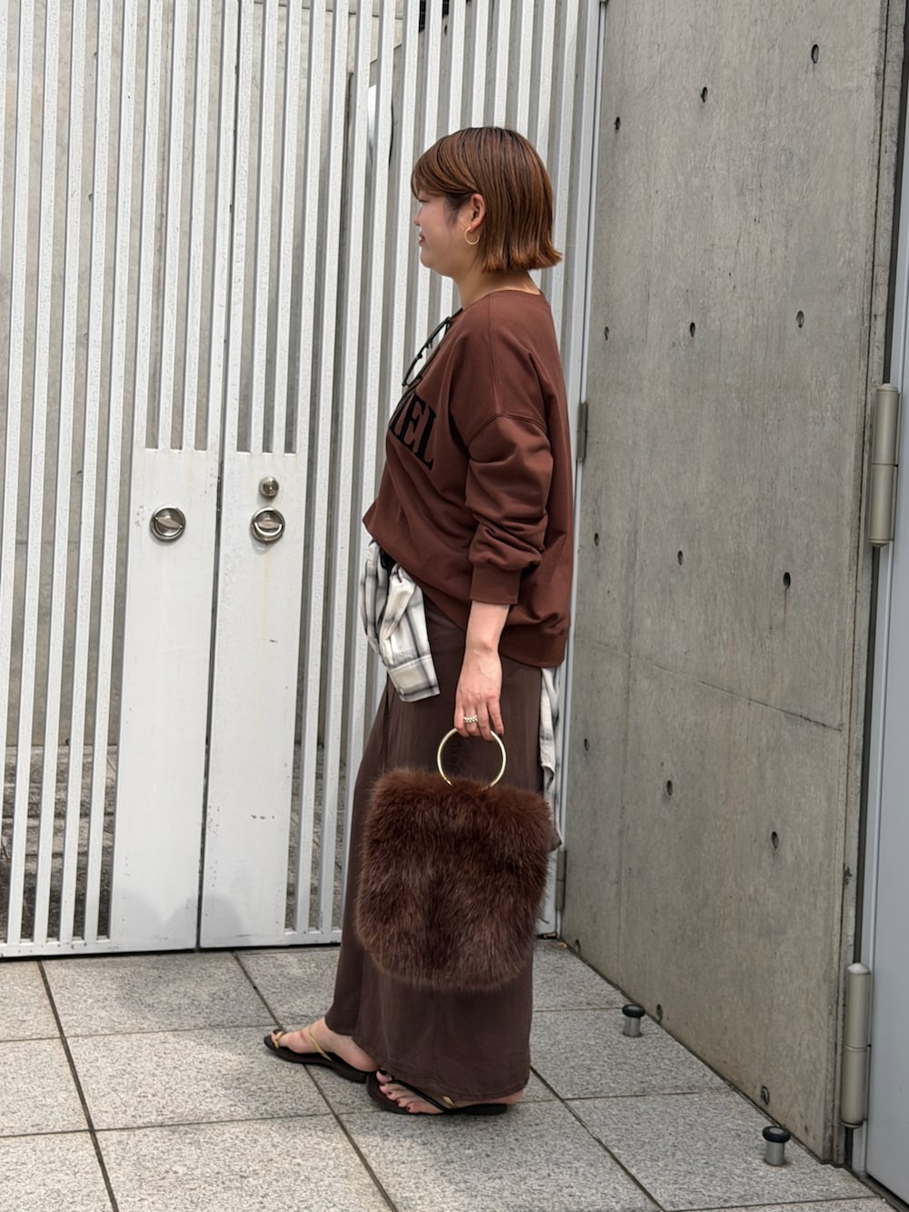 ホワイト系のシャツ/ブラウス、ブラウン系のスカート、ゴールド系のサンダルを着用したレディースの夏コーディネートの3枚目の写真