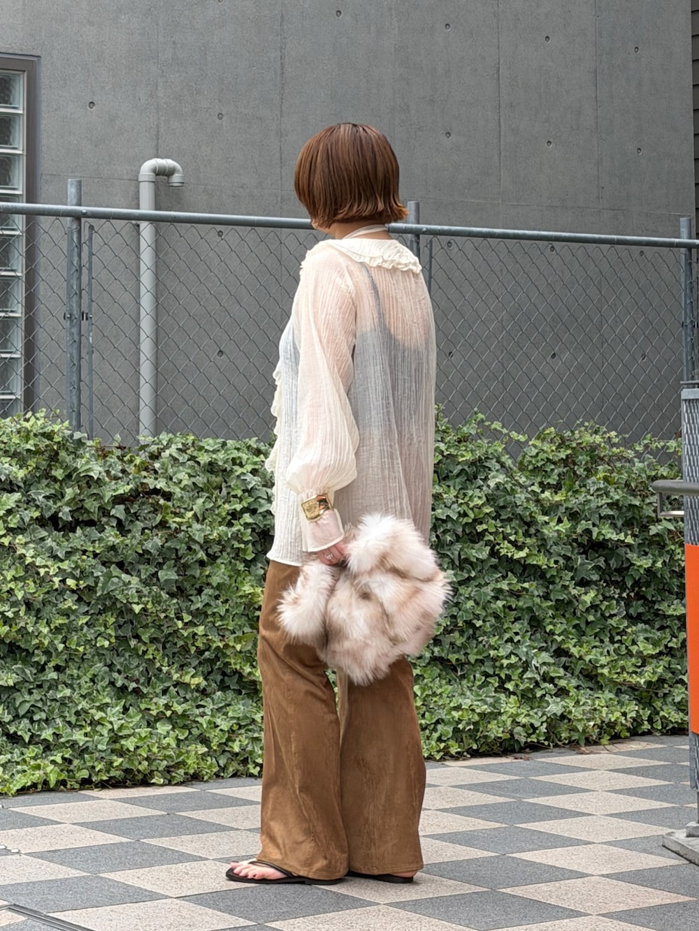 ホワイト系のシャツ/ブラウス、ホワイト系のクラッチバッグ、イエロー系のデニムパンツを着用したレディースの夏コーディネートの3枚目の写真