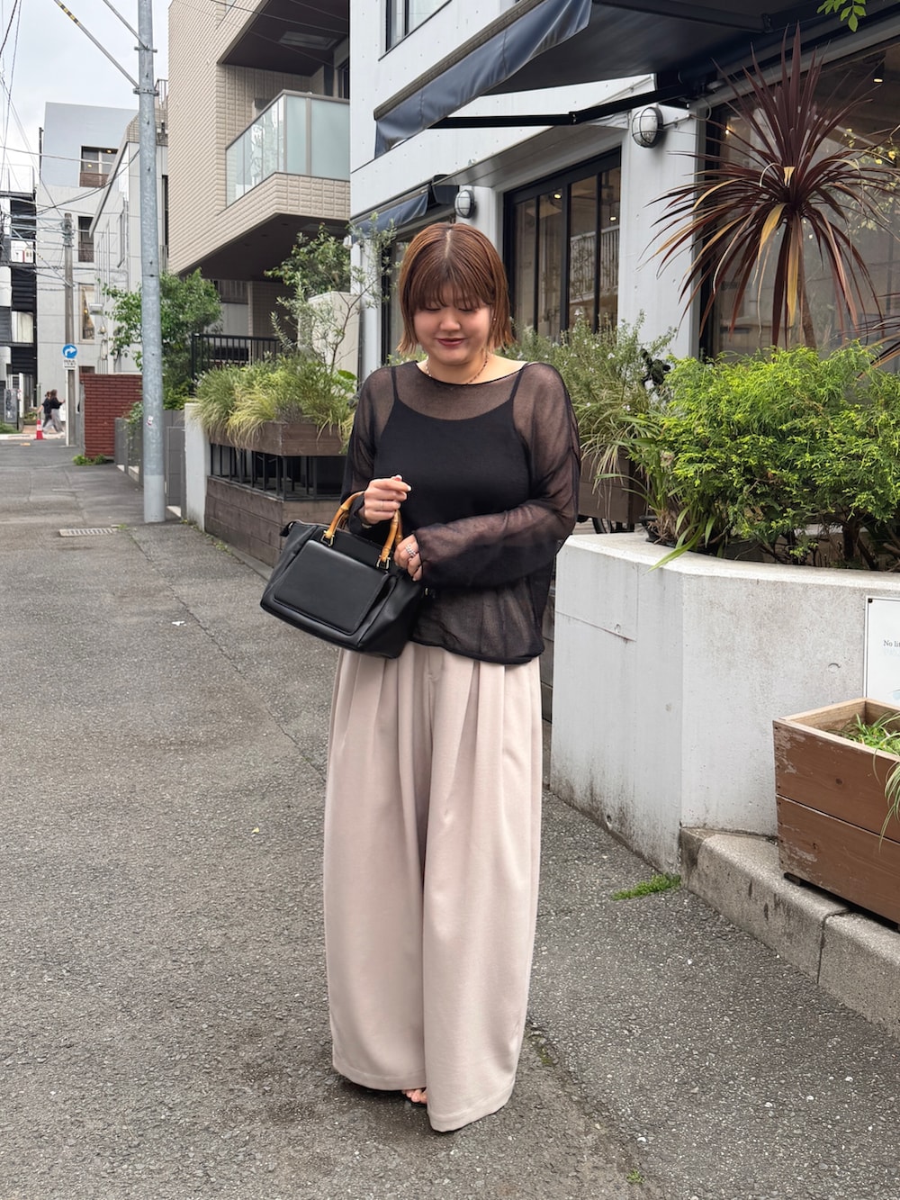 ブラック系のハンドバッグ、ベージュ系のその他パンツ、ブラック系のサンダルを着用したレディースの春コーディネートの3枚目の写真