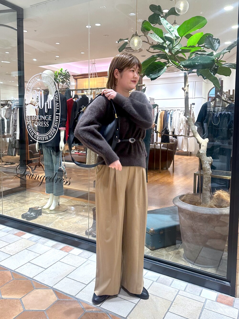 ブラック系のトートバッグ、ブラウン系のその他パンツ、ブラック系のローファーを着用したレディースの秋コーディネートの3枚目の写真