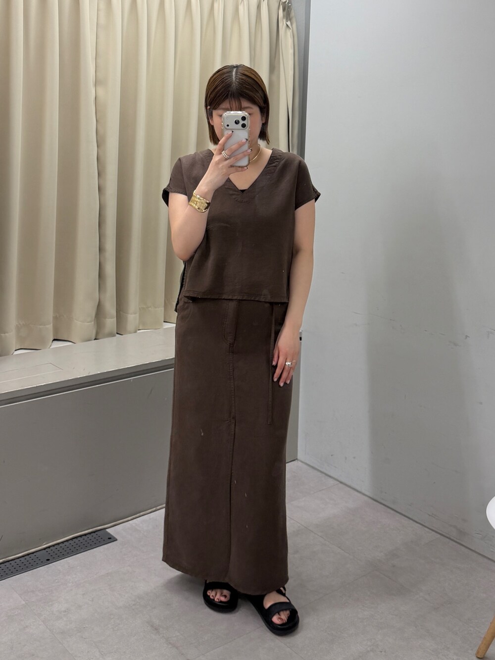 ブラウン系のシャツ/ブラウス、ブラウン系のスカート、ブラック系のサンダルを着用したレディースの夏コーディネートの3枚目の写真
