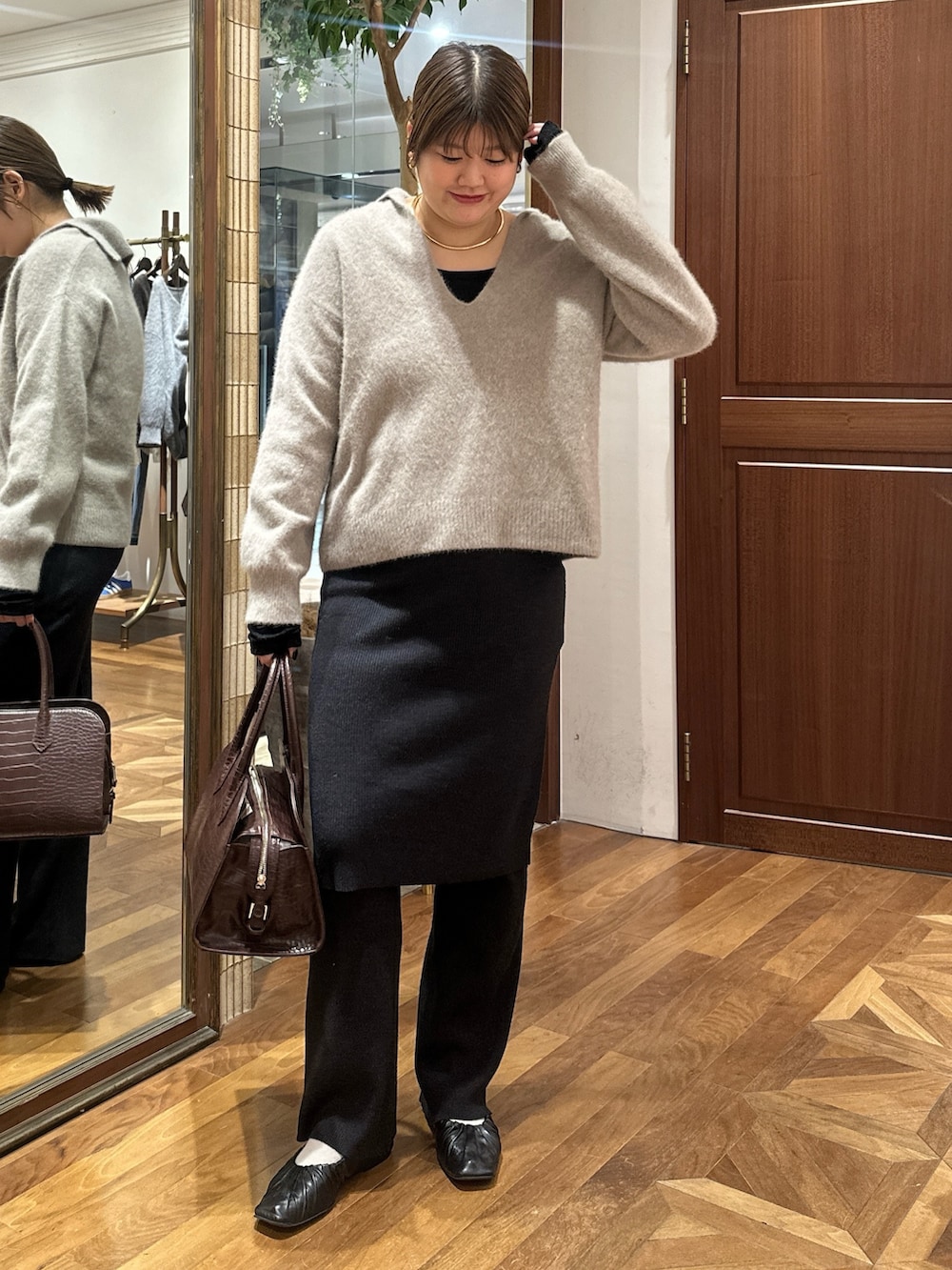 ブラウン系のニット/セーター、ブラック系のその他パンツ、ブラウン系のボストンバッグを着用したレディースの秋コーディネートの2枚目の写真