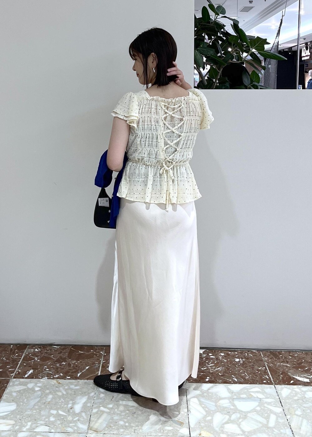 ブルー系のカーディガン/ボレロ、ブラック系のパンプス、ホワイト系のスカートを着用したレディースの夏コーディネートの5枚目の写真