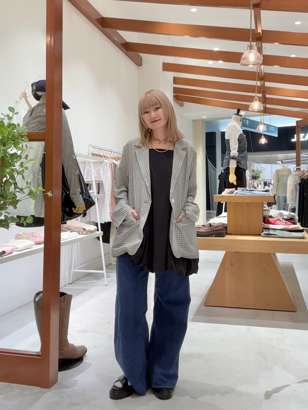 ブラック系のワンピース、グレー系のテーラードジャケット、ブルー系のデニムパンツを着用したレディースの夏コーディネートの3枚目の写真