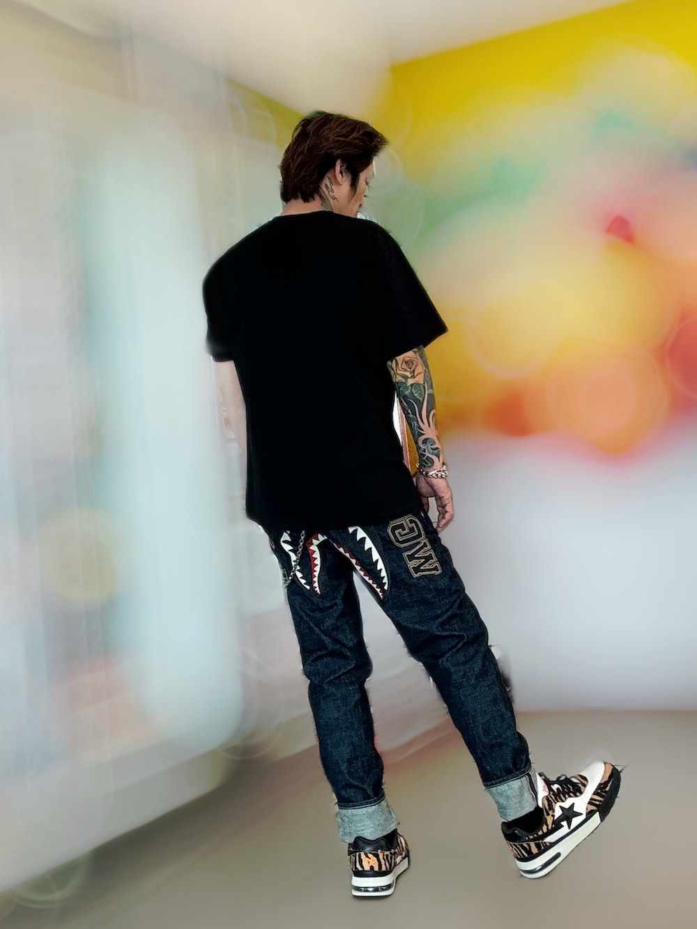 その他のデニムパンツ、その他のスニーカー、ブラック系のTシャツ/カットソーを着用したメンズの春コーディネートの3枚目の写真