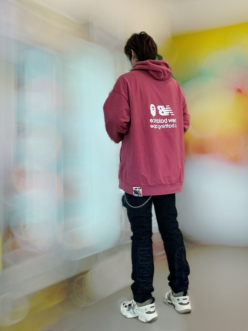 ピンク系のパーカー、ブラック系のデニムパンツ、ベージュ系のスニーカーを着用したメンズの春コーディネートの3枚目の写真