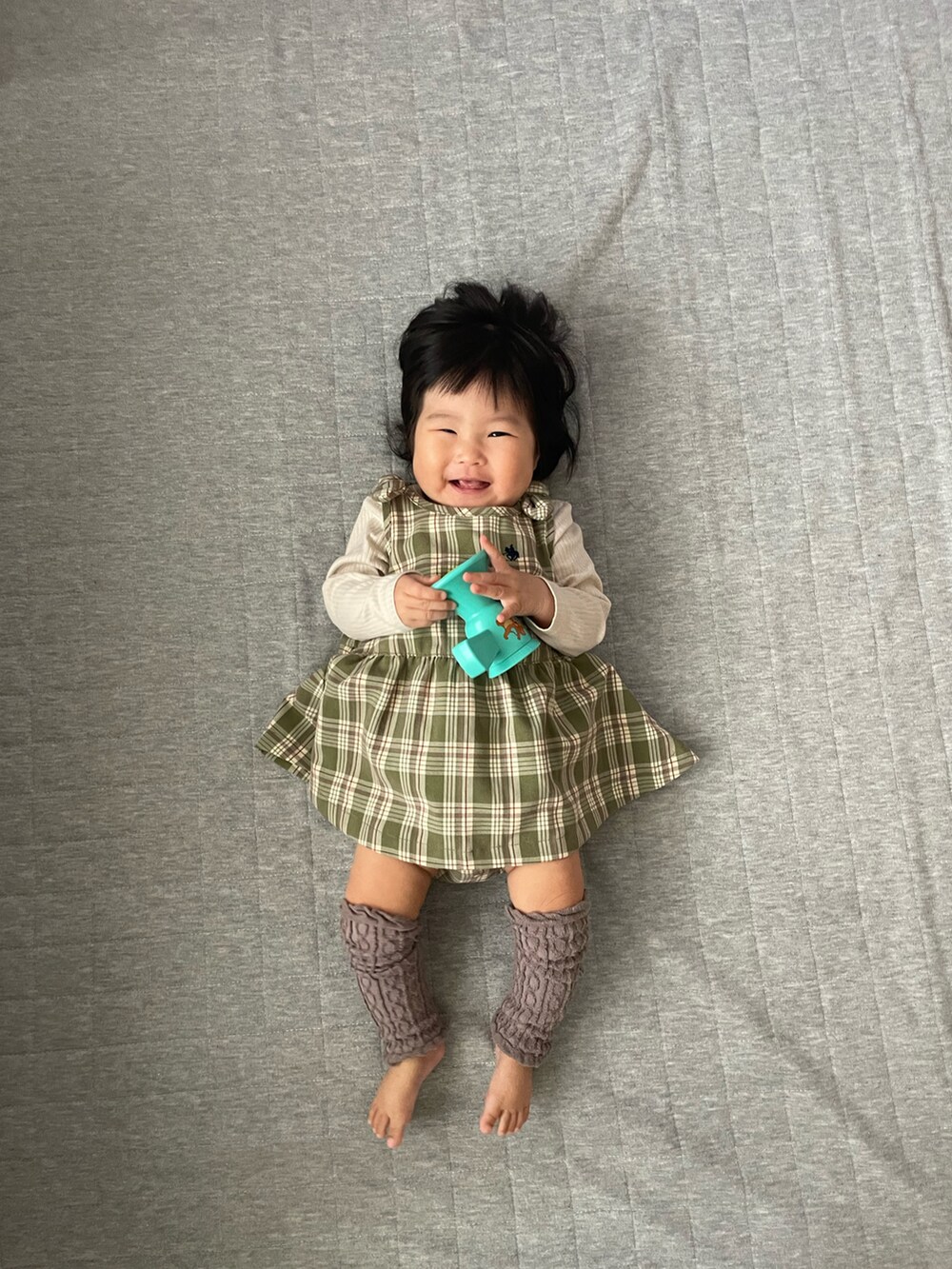 グリーン系のワンピース/ドレス、ベージュ系のトップス、ブラウン系のレッグウォーマーを着用したキッズの秋コーディネートの2枚目の写真