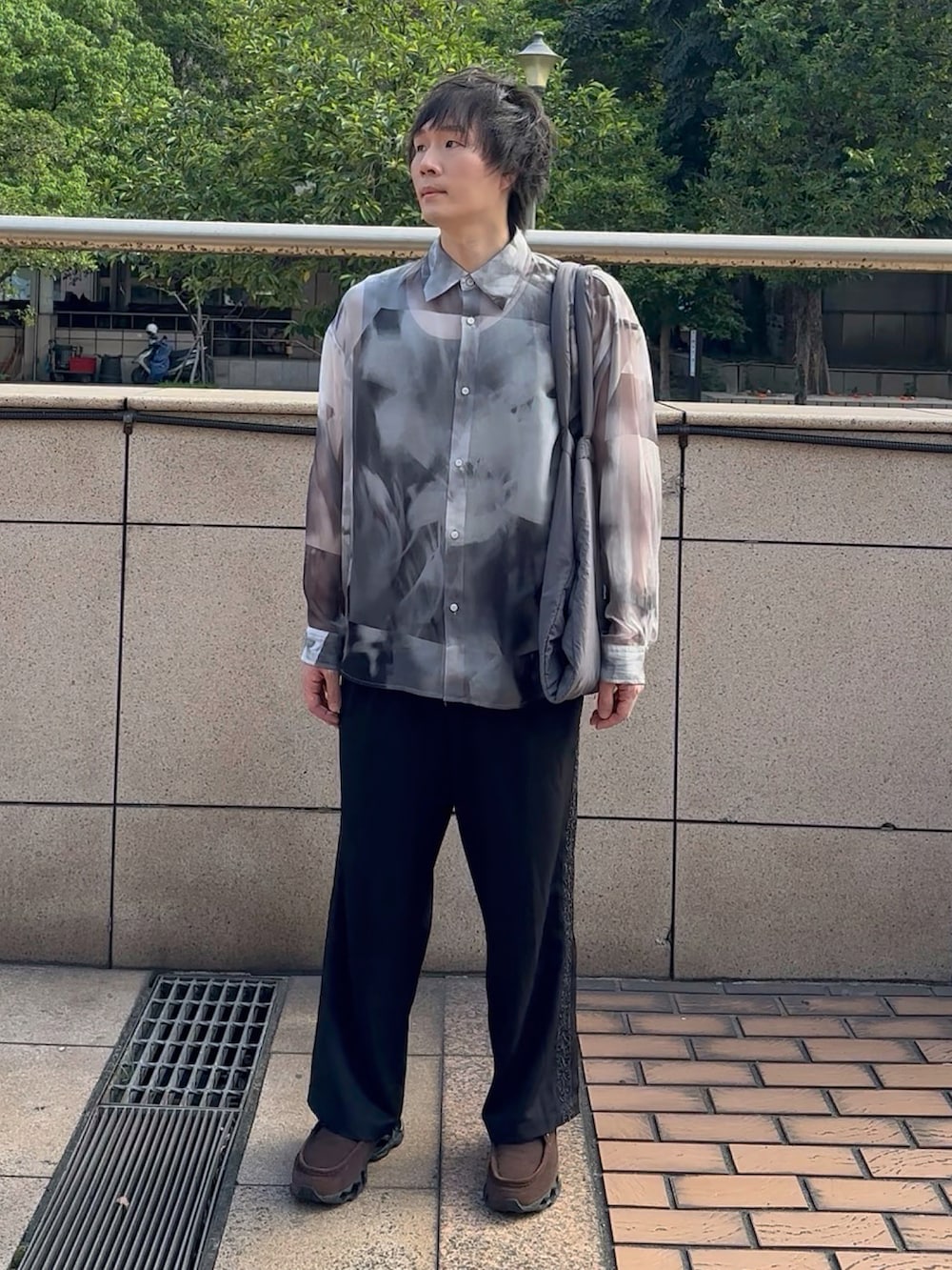 グレー系のトートバッグ、ホワイト系のシャツ/ブラウス、ブラック系のスラックスを着用したメンズの夏コーディネートの2枚目の写真