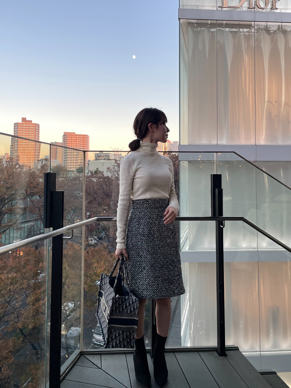 ブラック系のスカート、ブラック系のブーツを着用したレディースの冬コーディネートの2枚目の写真