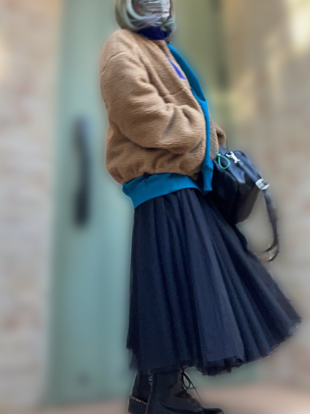 ベージュ系のブルゾン、ブラック系のスカート、ブラック系のブーツを着用したレディースの冬コーディネートの2枚目の写真