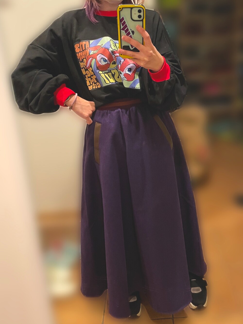 ブラック系のスウェット、パープル系のスカート、パープル系のその他アウターを着用したレディースの冬コーディネートの2枚目の写真