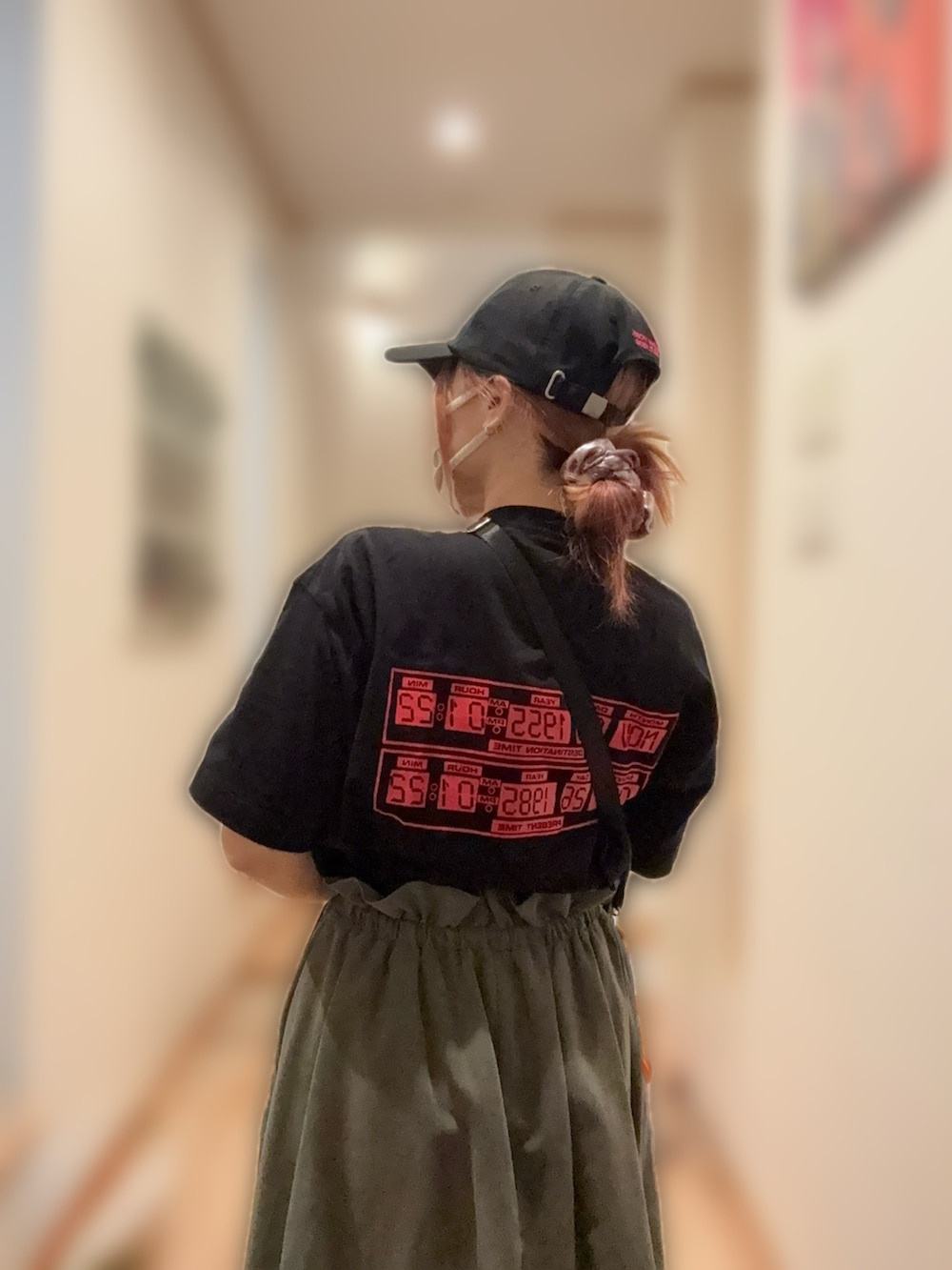 グリーン系のスカート、ブラック系のショルダーバッグ、ブラック系のTシャツ/カットソーを着用したレディースの夏コーディネートの2枚目の写真