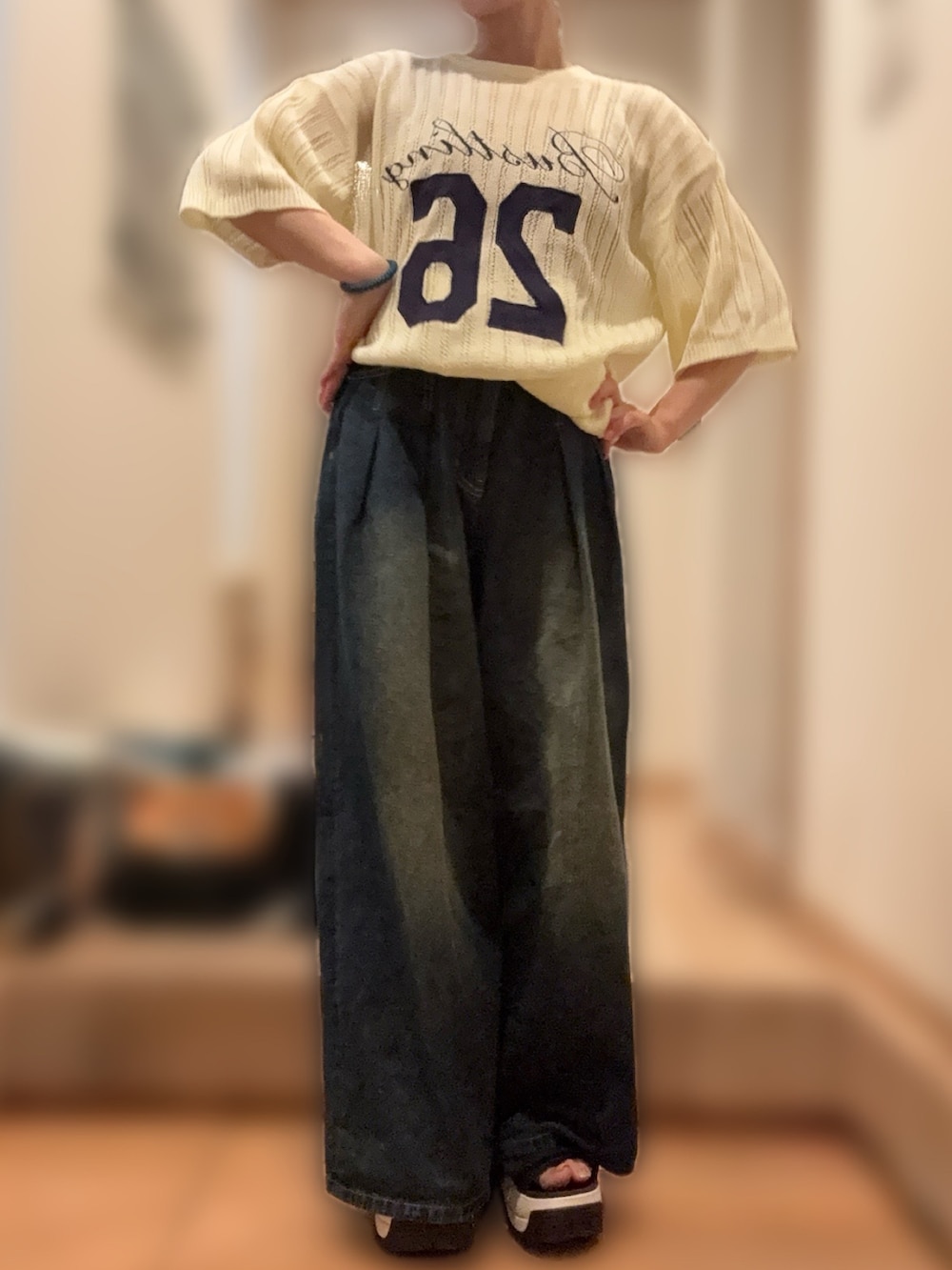 ホワイト系のニット/セーター、ブルー系のデニムパンツ、ブラック系のサンダルを着用したレディースの夏コーディネートの2枚目の写真