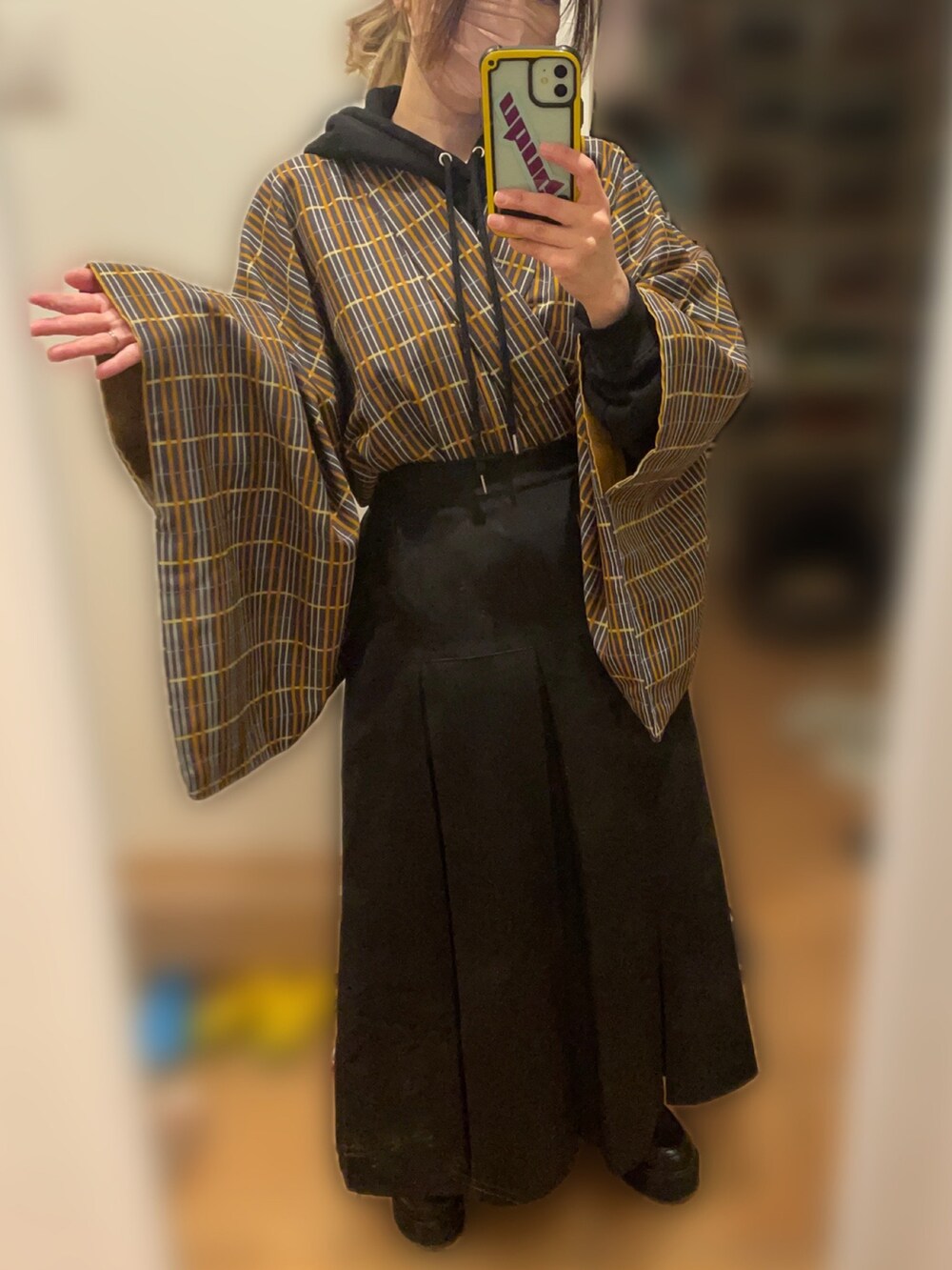 ブラック系のスカート、ブラック系のブーツ、ブラック系のパーカーを着用したレディースの冬コーディネートの2枚目の写真