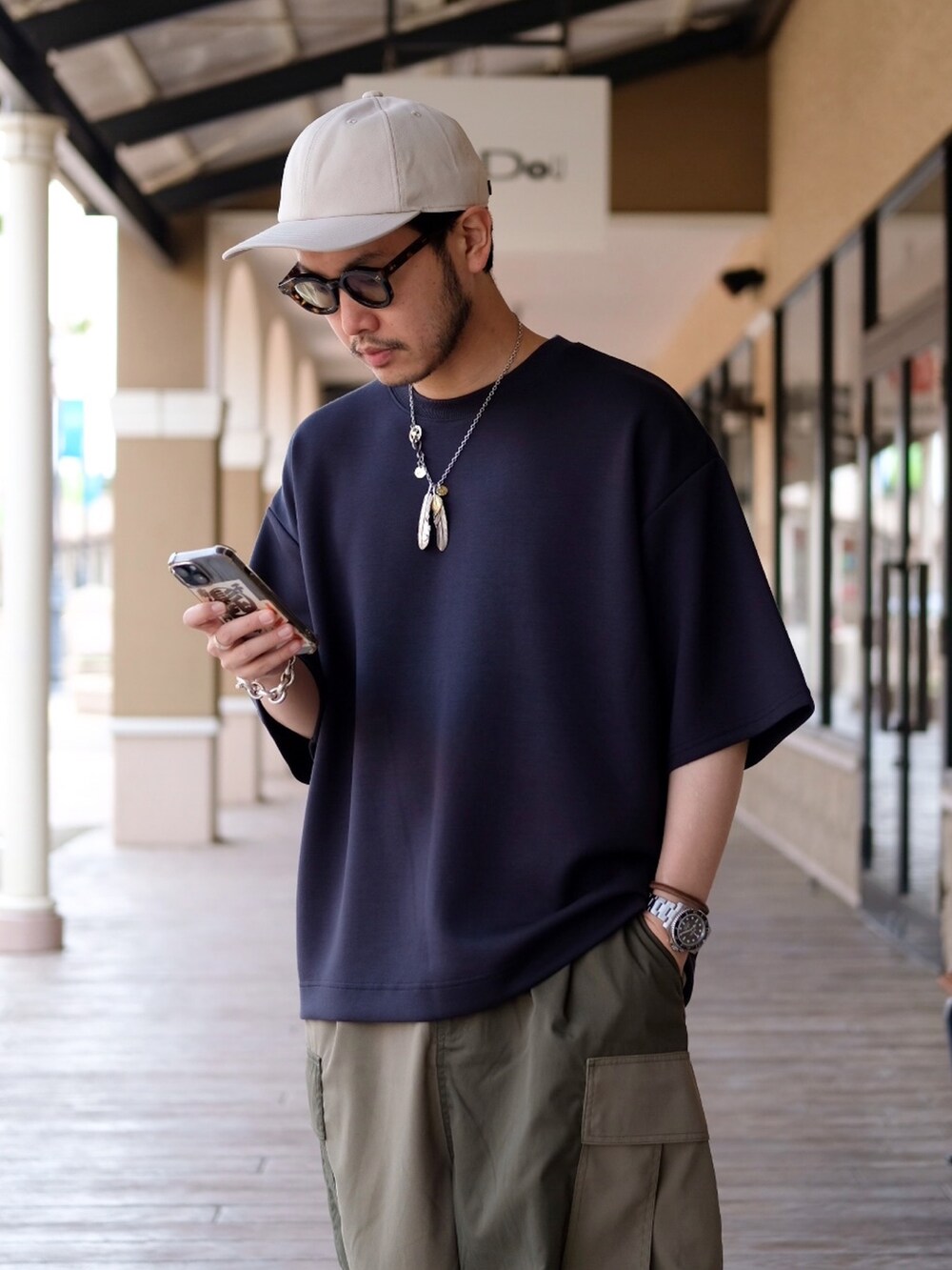 グレー系のTシャツ/カットソー、グリーン系のカーゴパンツを着用したメンズの春コーディネートの2枚目の写真