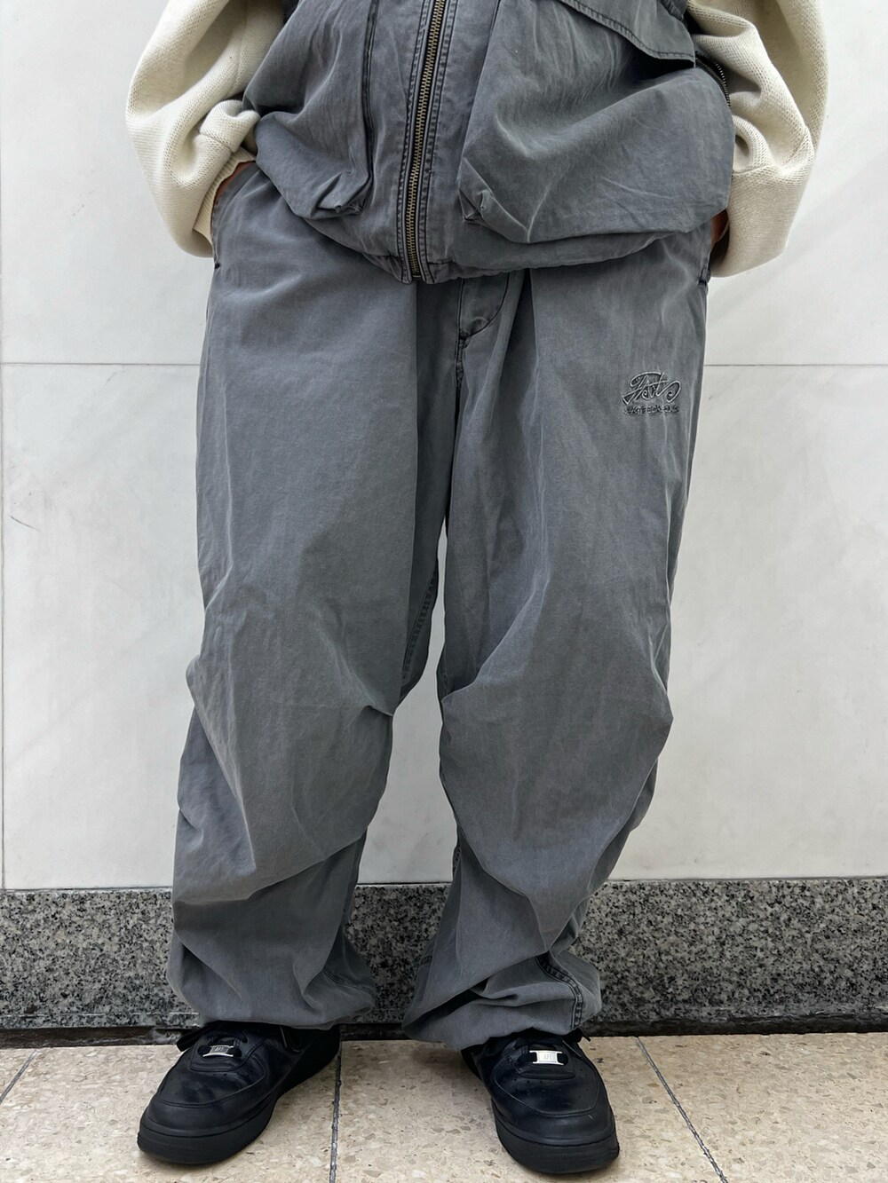 ホワイト系のニット/セーター、グレー系のベスト、グレー系のカーゴパンツを着用したレディースの秋コーディネートの4枚目の写真