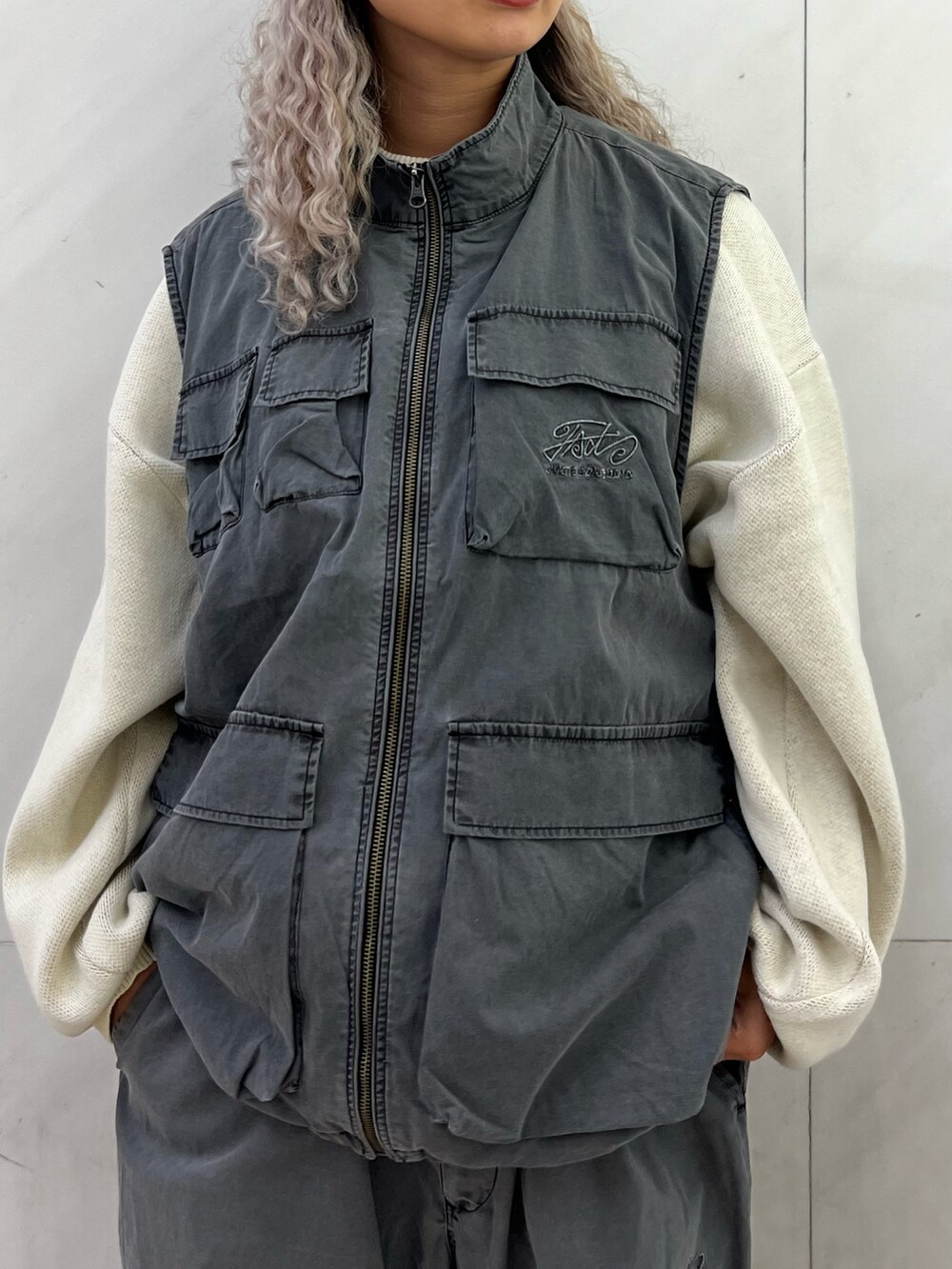 ホワイト系のニット/セーター、グレー系のベスト、グレー系のカーゴパンツを着用したレディースの秋コーディネートの3枚目の写真