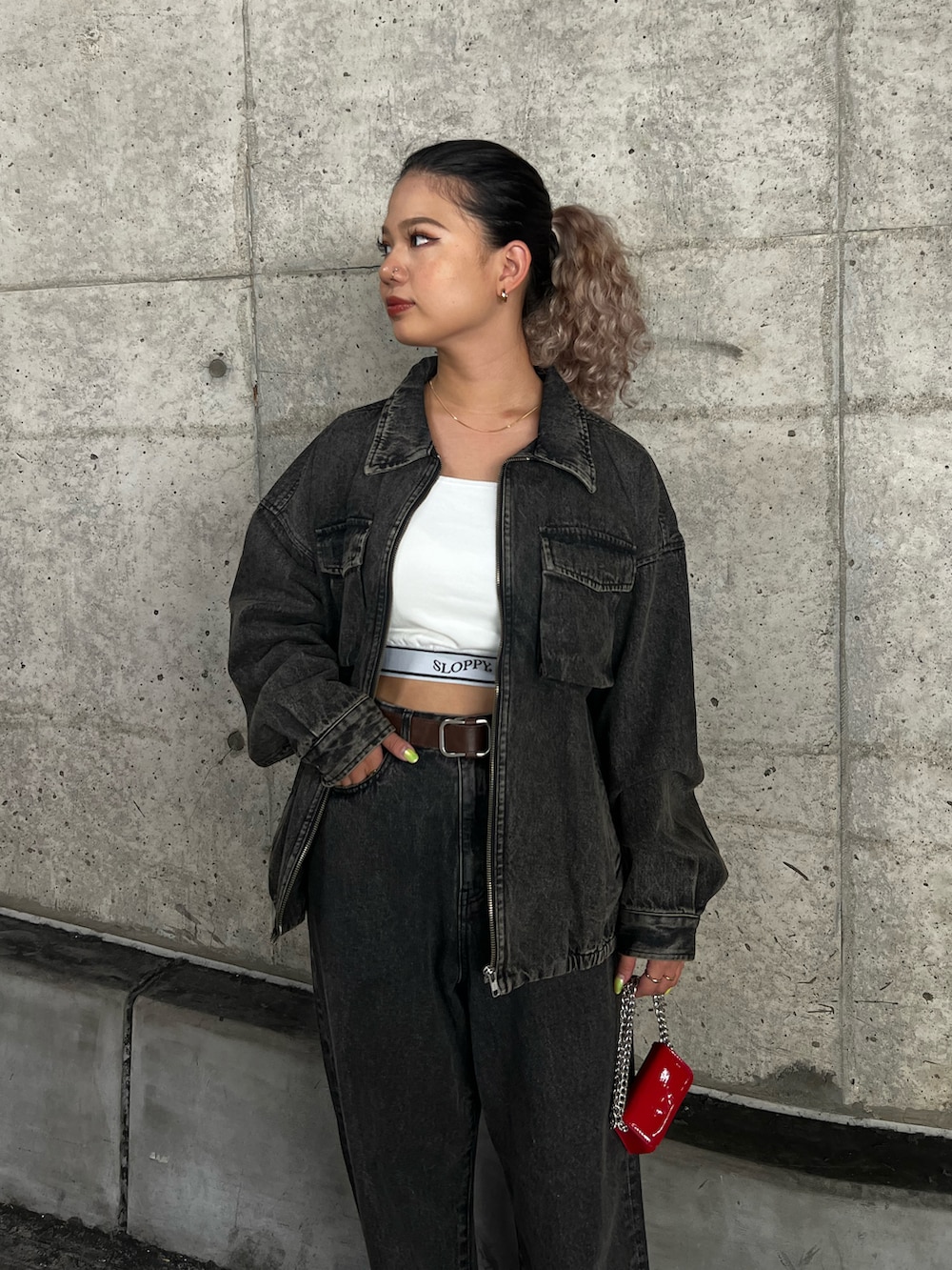 ブラウン系のブルゾン、ホワイト系のキャミソール、ブラウン系のデニムパンツを着用したレディースの秋コーディネートの2枚目の写真