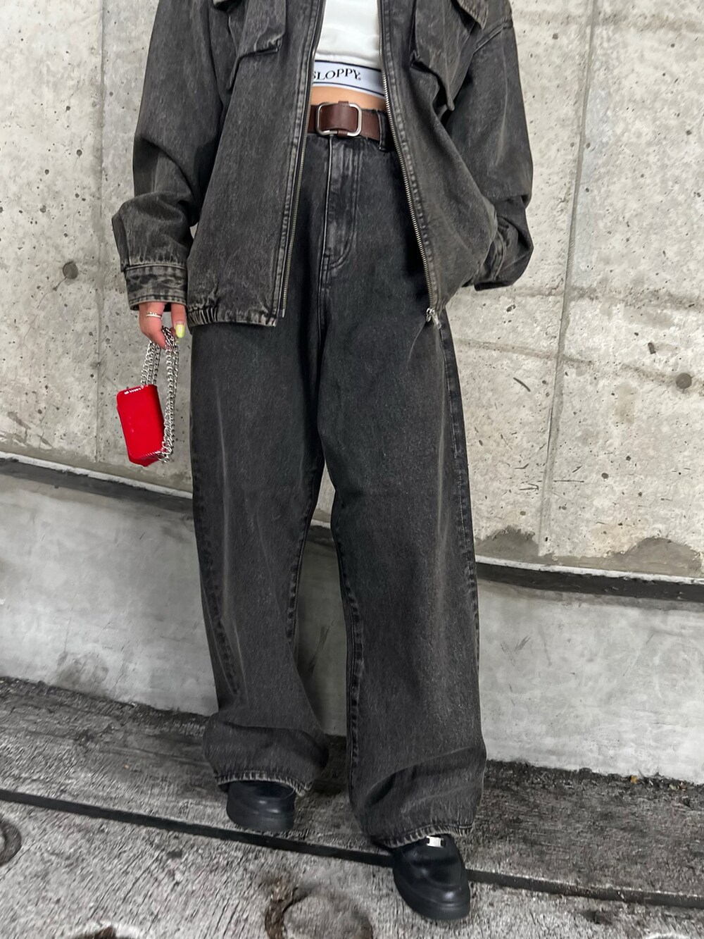 ブラウン系のブルゾン、ホワイト系のキャミソール、ブラウン系のデニムパンツを着用したレディースの秋コーディネートの4枚目の写真