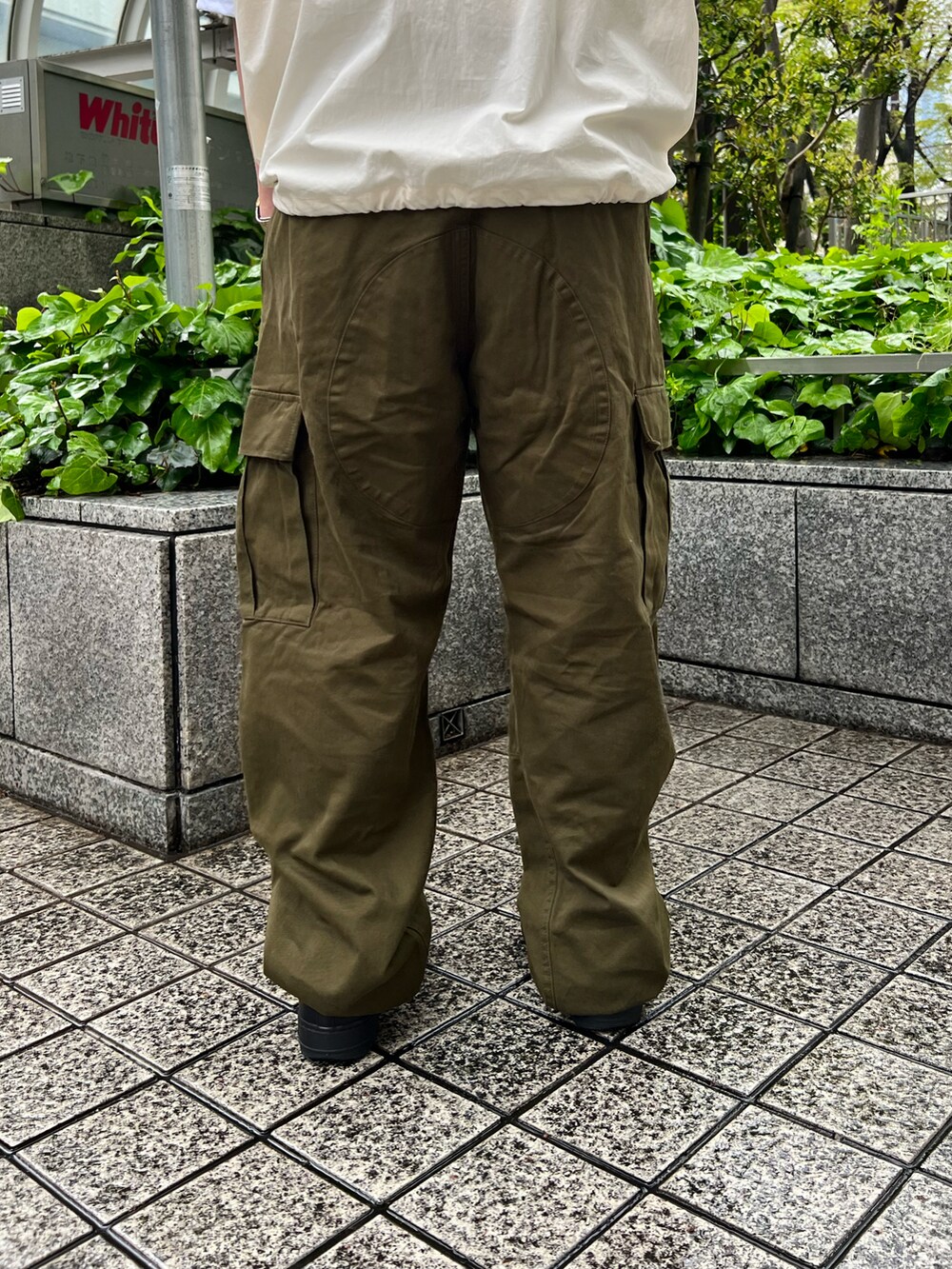 ホワイト系のベスト、グリーン系のカーゴパンツ、ホワイト系のTシャツ/カットソーを着用したレディースの春コーディネートの4枚目の写真