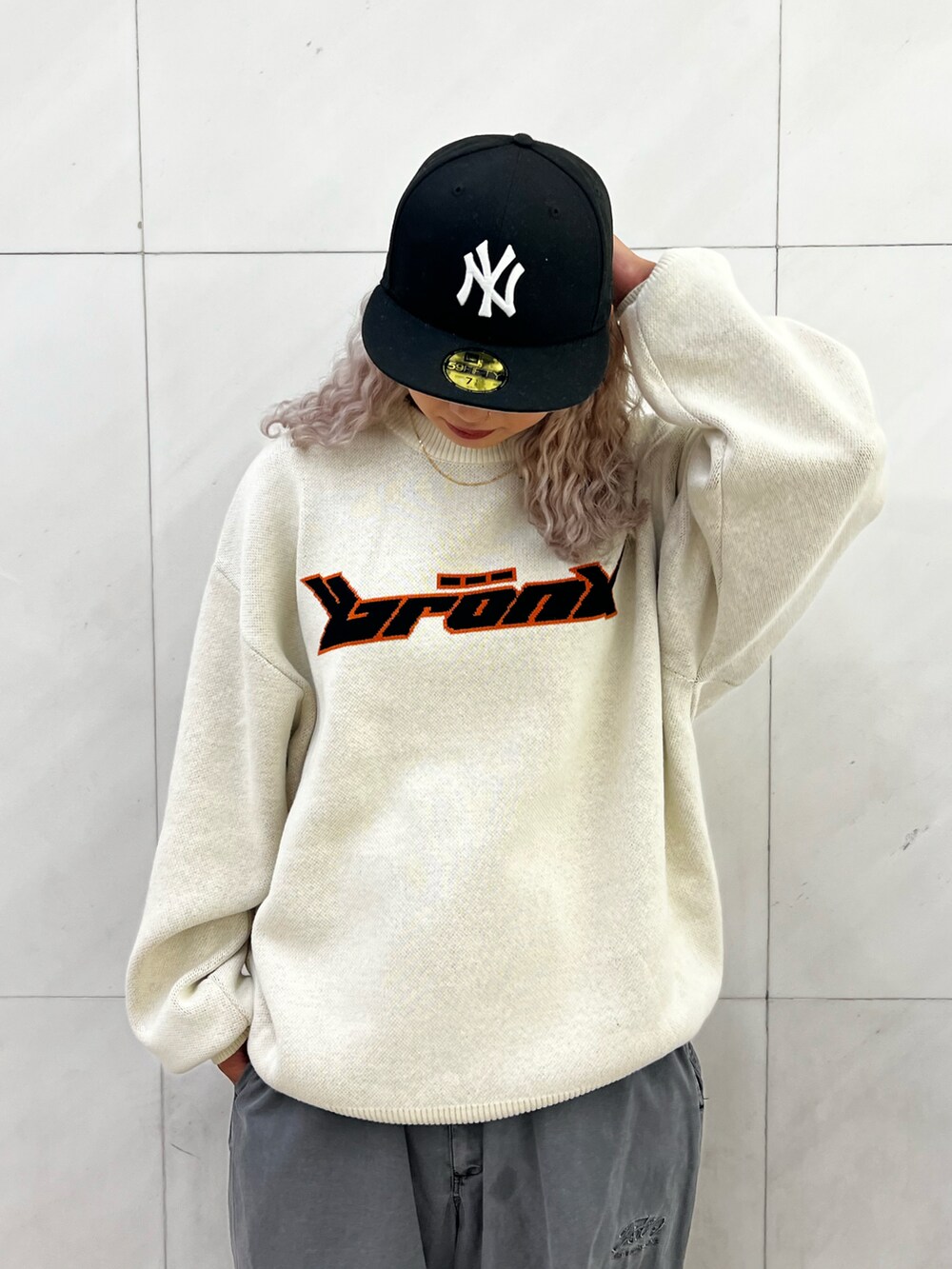 ホワイト系のニット/セーター、グレー系のベスト、グレー系のカーゴパンツを着用したレディースの秋コーディネートの5枚目の写真