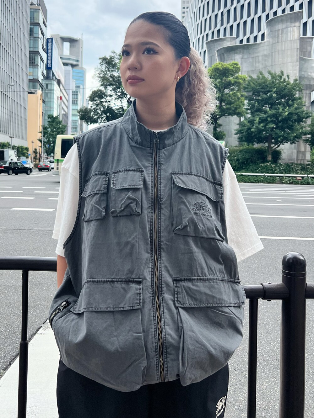 グレー系のベスト、ブラック系のカーゴパンツを着用したレディースの夏コーディネートの2枚目の写真