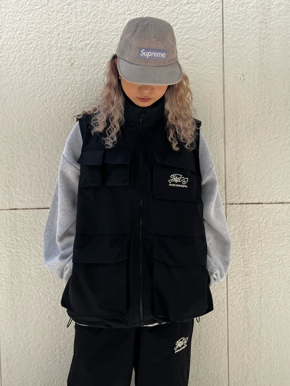 ブラック系のベスト、ブラック系のカーゴパンツ、グレー系のニット/セーターを着用したレディースの秋コーディネートの2枚目の写真