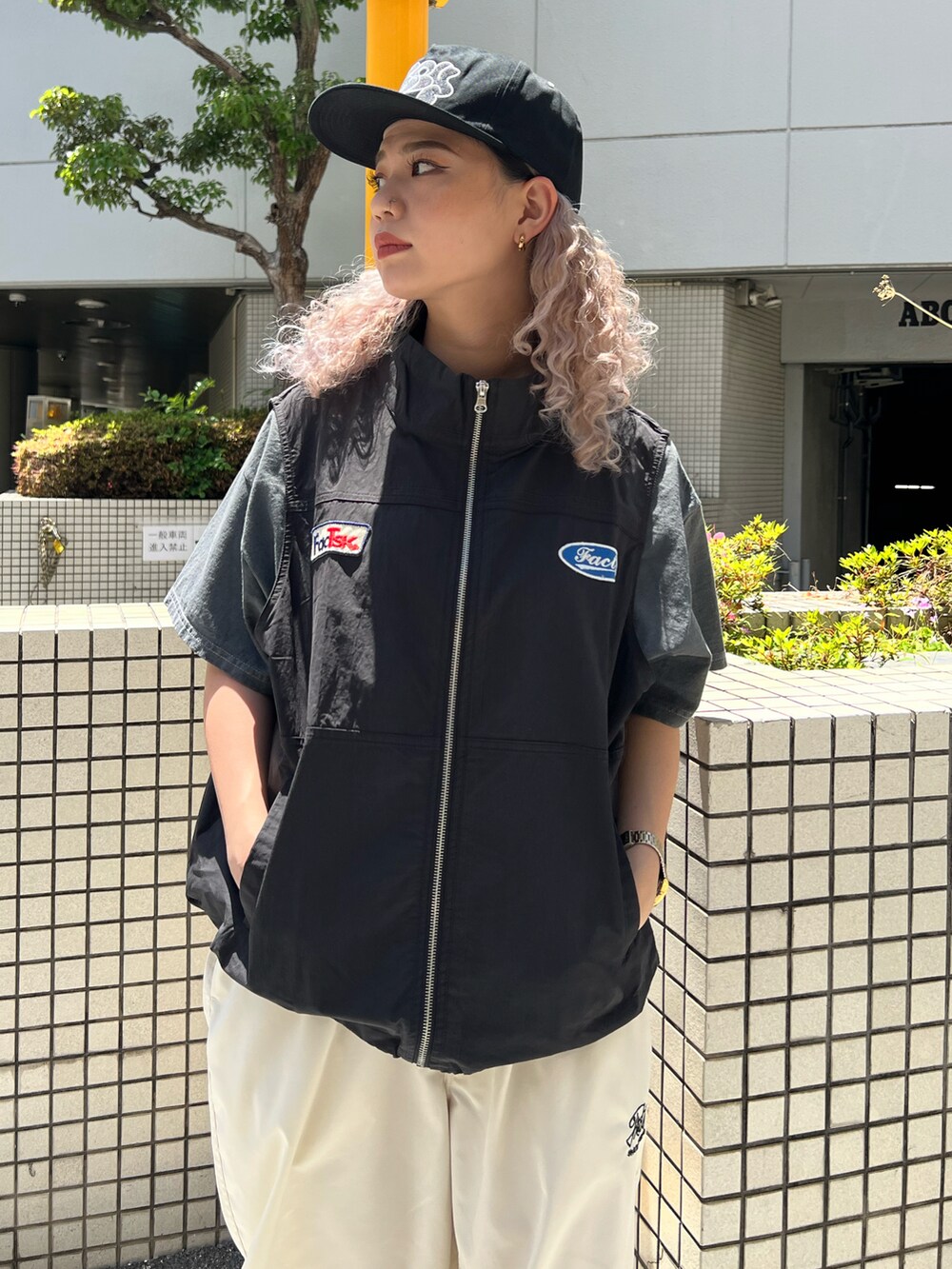 ブラック系のベスト、グレー系のTシャツ/カットソー、ホワイト系のカーゴパンツを着用したレディースの夏コーディネートの2枚目の写真