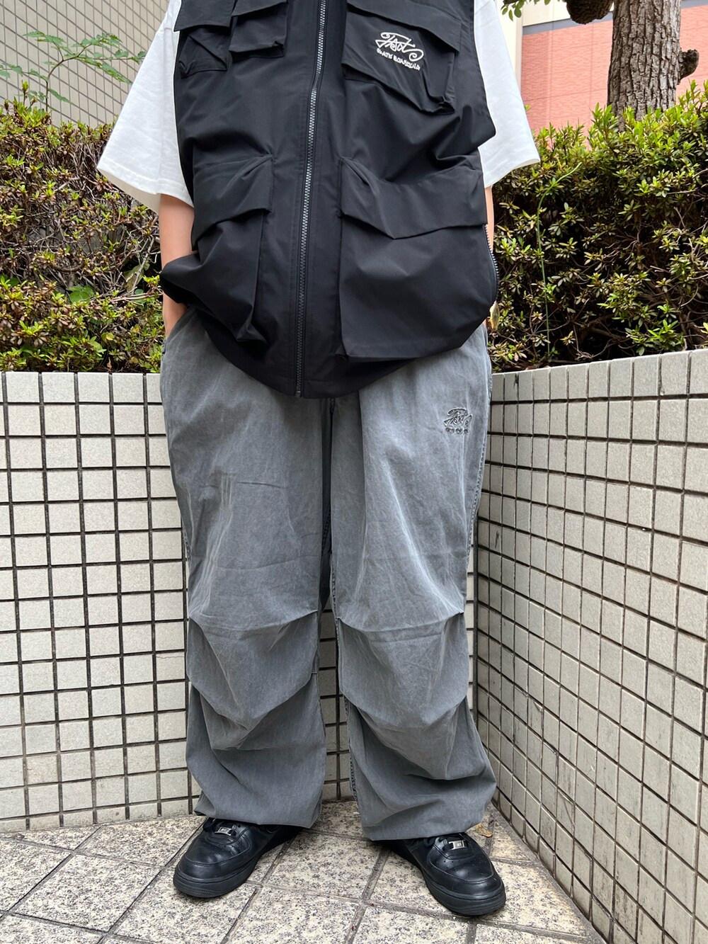 ブラック系のベスト、グレー系のカーゴパンツ、ブラウン系のキャップを着用したレディースの夏コーディネートの4枚目の写真