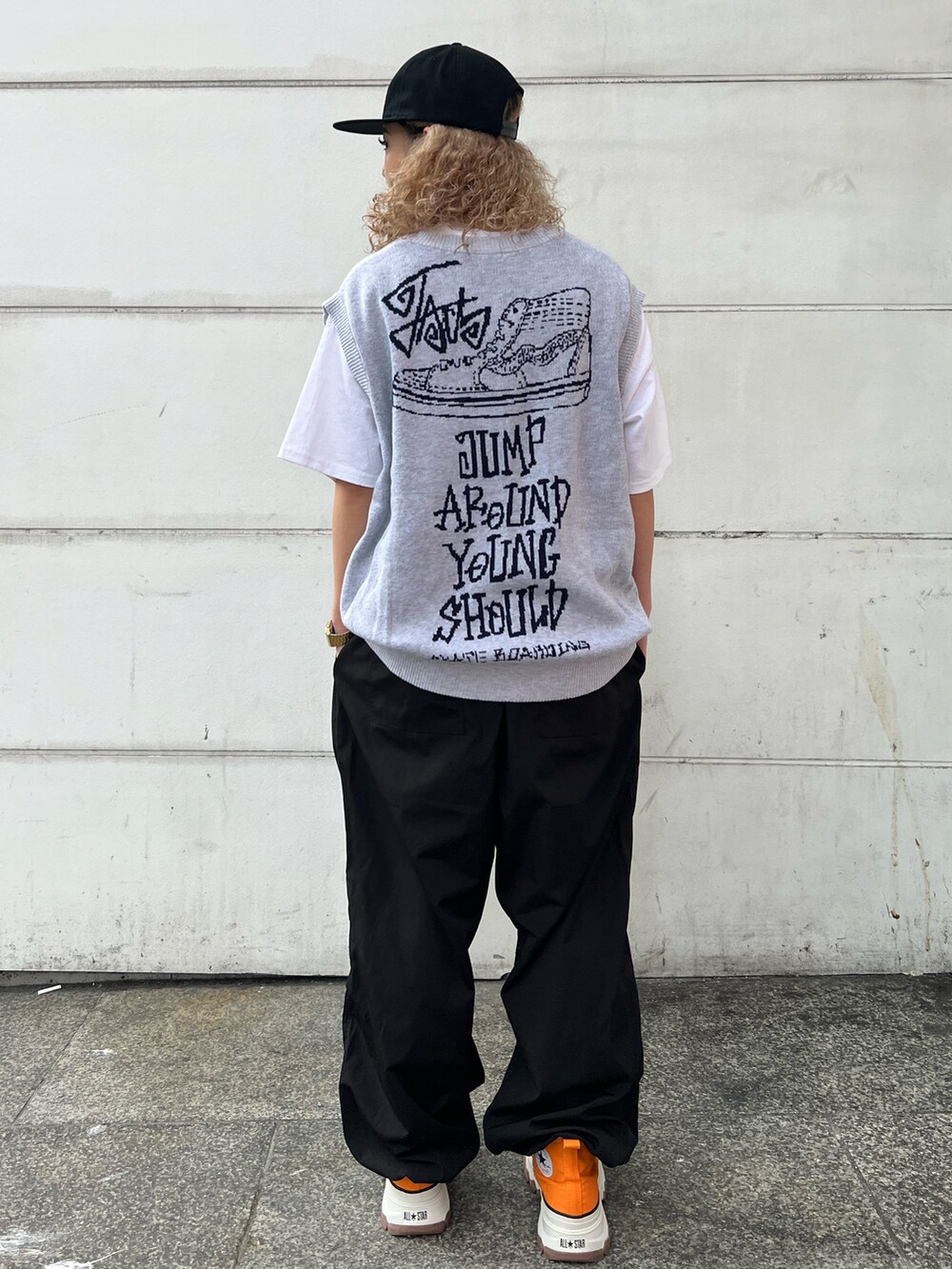 グレー系のベスト、ホワイト系のTシャツ/カットソー、ブラック系のカーゴパンツを着用したレディースの春コーディネートの2枚目の写真