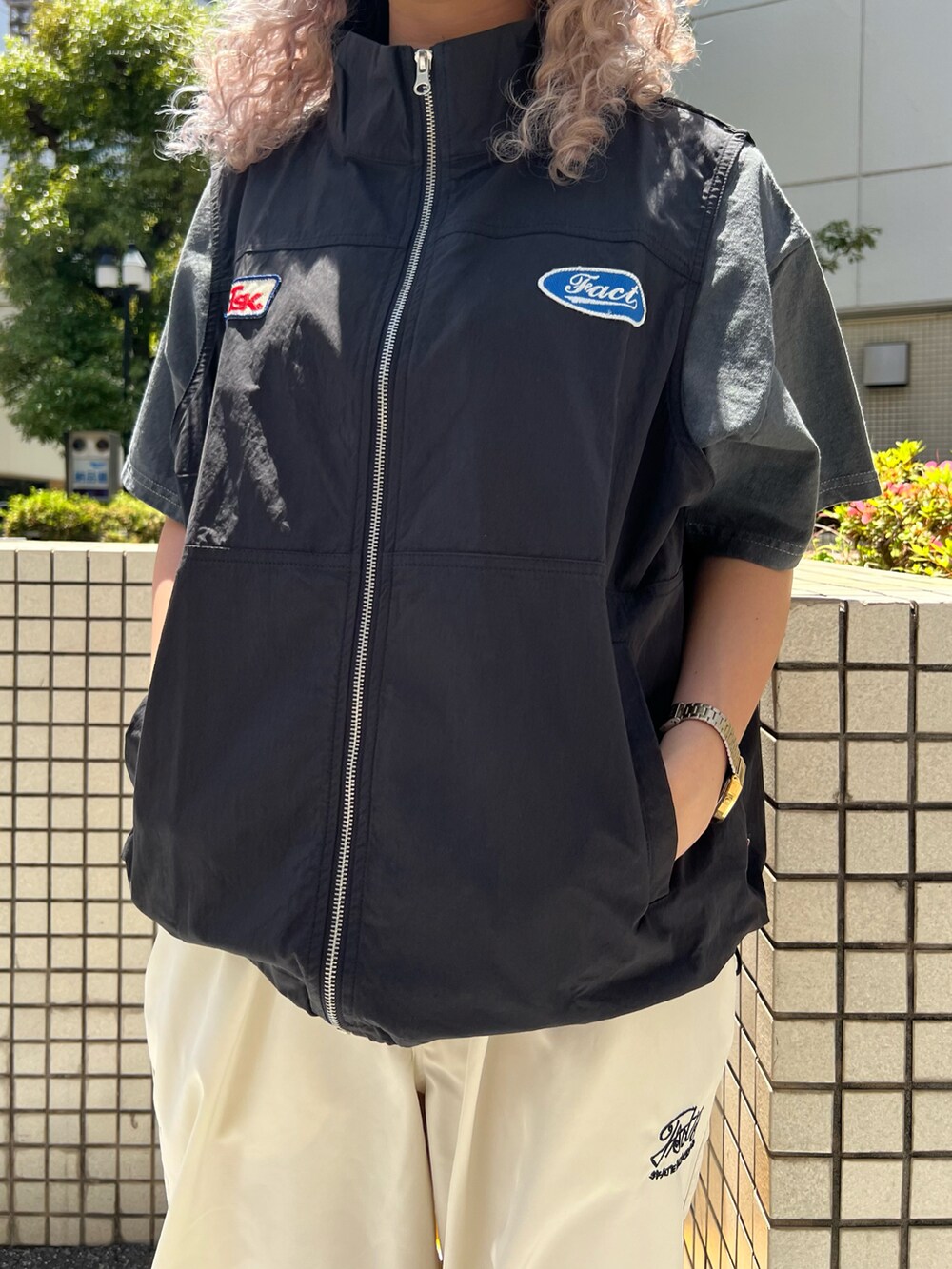 ブラック系のベスト、グレー系のTシャツ/カットソー、ホワイト系のカーゴパンツを着用したレディースの夏コーディネートの3枚目の写真