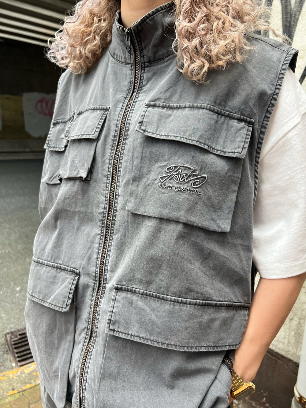 グレー系のベスト、グレー系のカーゴパンツ、ブラック系のニットキャップ/ビーニーを着用したレディースの夏コーディネートの4枚目の写真