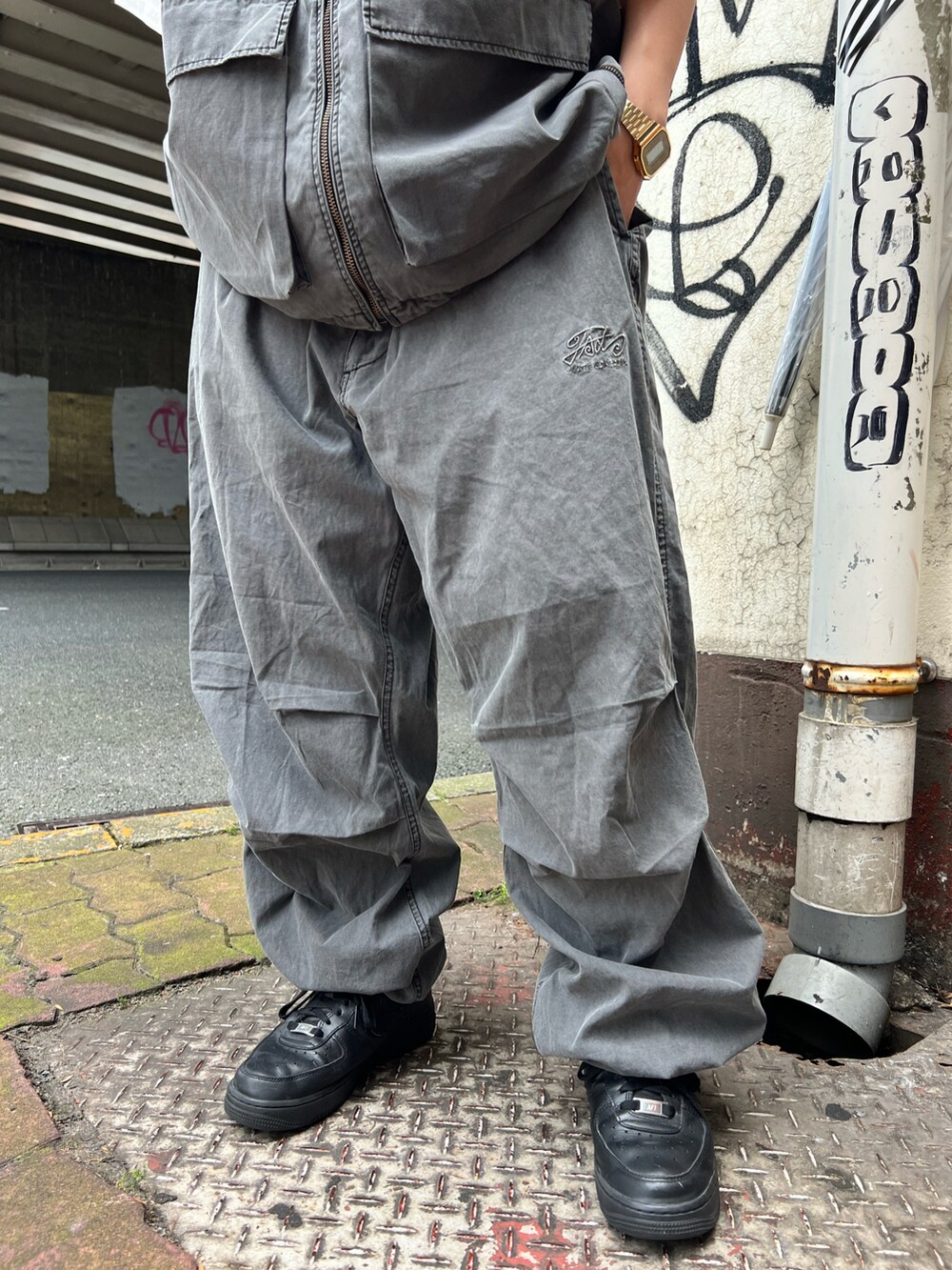 グレー系のベスト、グレー系のカーゴパンツ、ブラック系のニットキャップ/ビーニーを着用したレディースの夏コーディネートの5枚目の写真