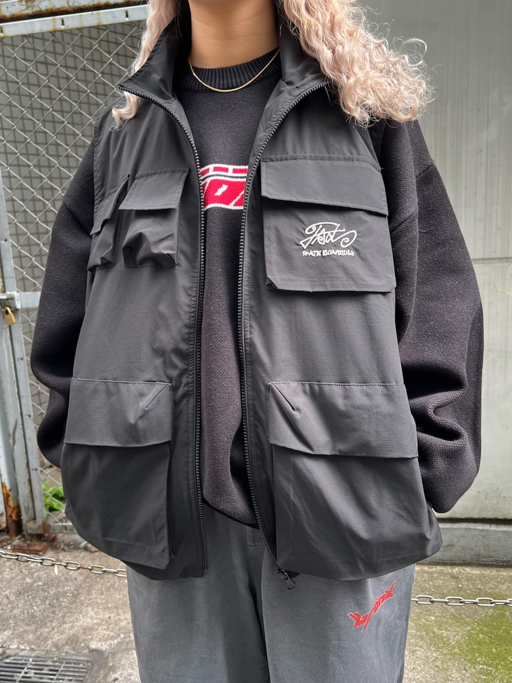 ブラック系のベスト、ブラック系のニット/セーター、グレー系のスウェットパンツを着用したレディースの秋コーディネートの3枚目の写真