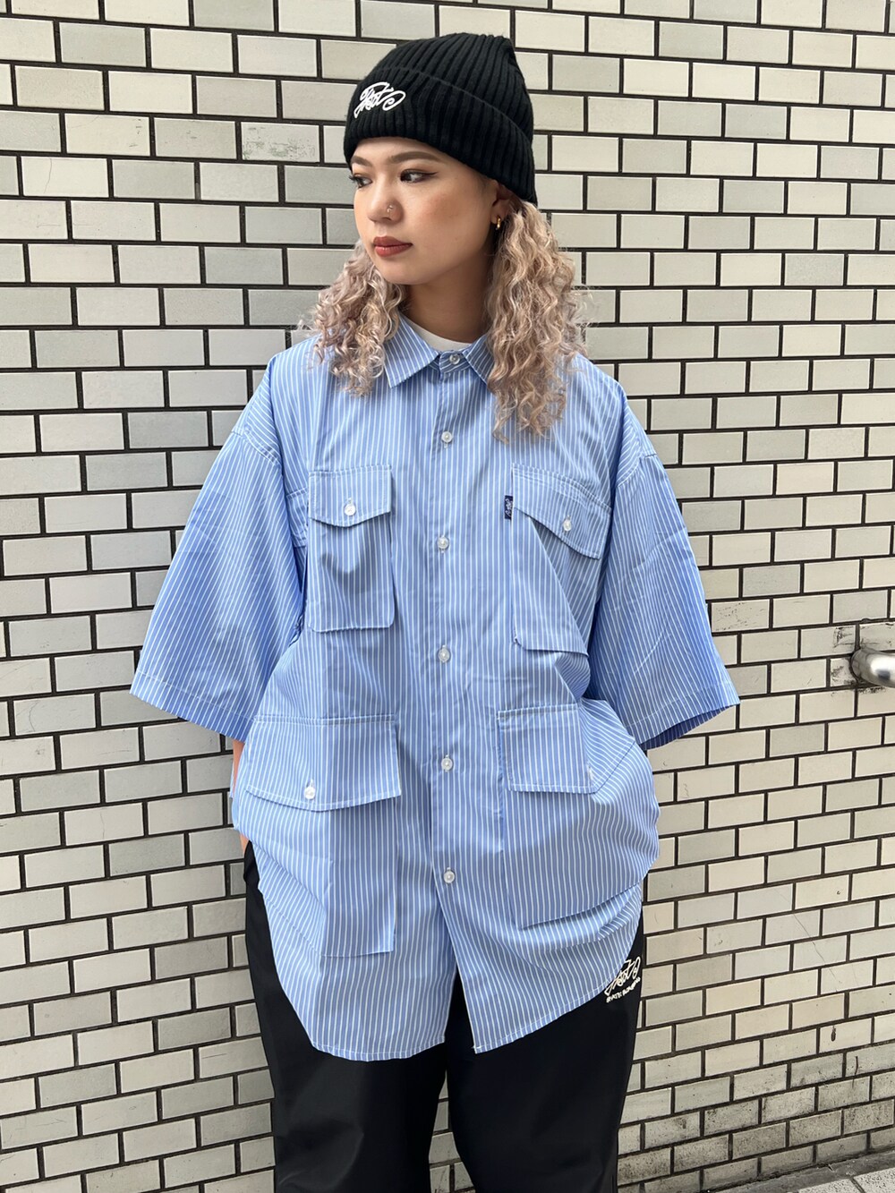 ブルー系のシャツ/ブラウス、ブラック系のカーゴパンツ、ブラック系のニットキャップ/ビーニーを着用したレディースの夏コーディネートの2枚目の写真