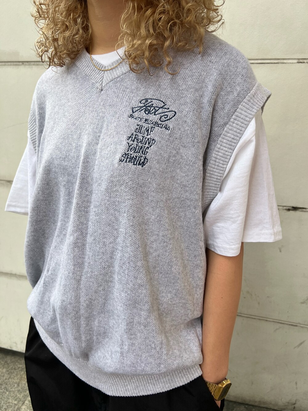 グレー系のベスト、ホワイト系のTシャツ/カットソー、ブラック系のカーゴパンツを着用したレディースの春コーディネートの4枚目の写真