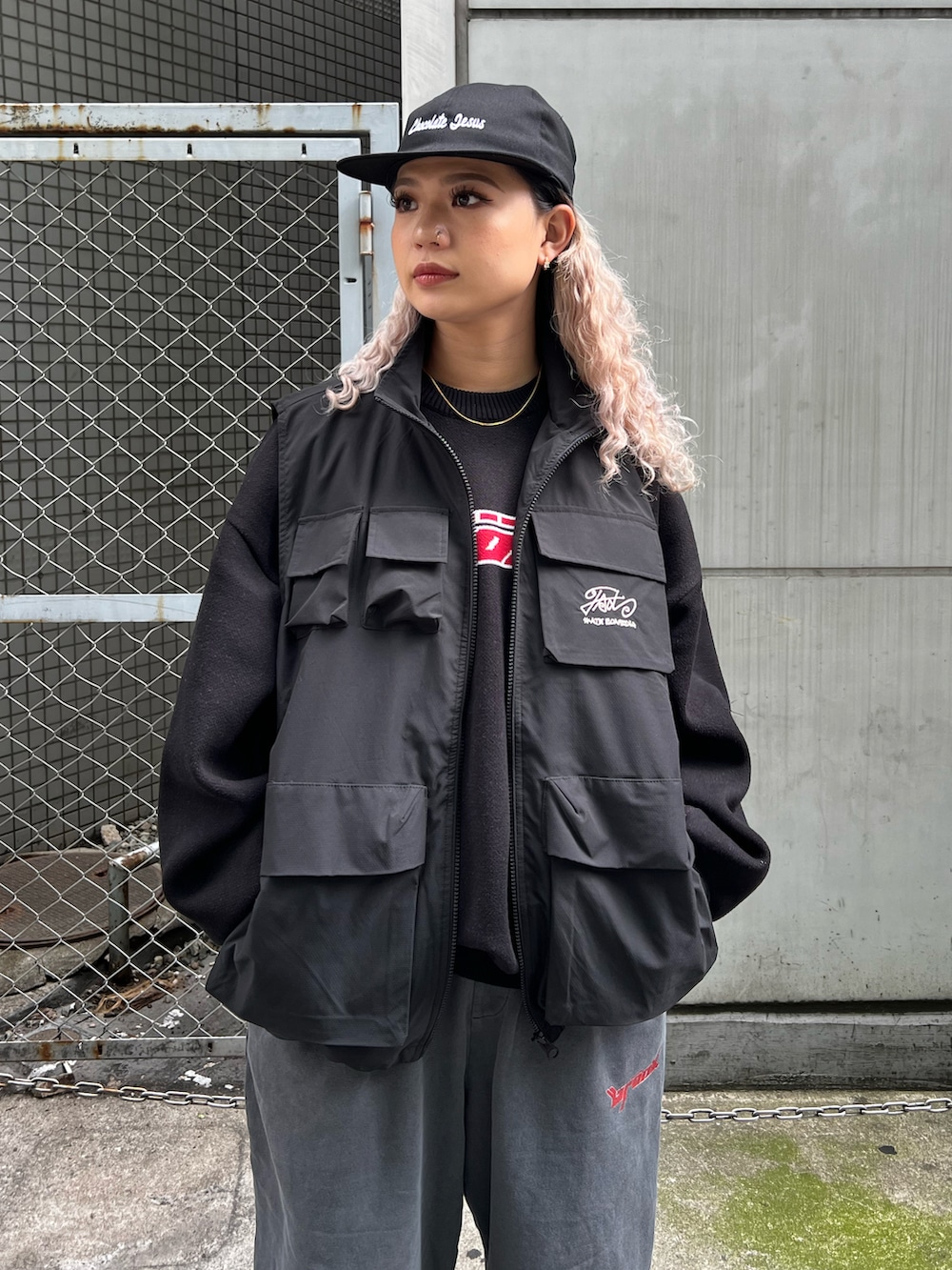 ブラック系のベスト、ブラック系のニット/セーター、グレー系のスウェットパンツを着用したレディースの秋コーディネートの2枚目の写真