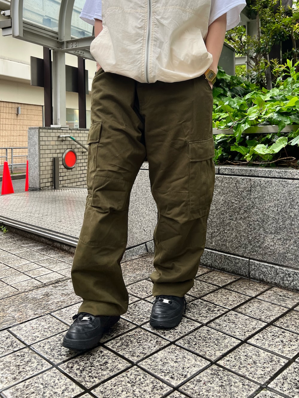 ホワイト系のベスト、グリーン系のカーゴパンツ、ホワイト系のTシャツ/カットソーを着用したレディースの春コーディネートの3枚目の写真