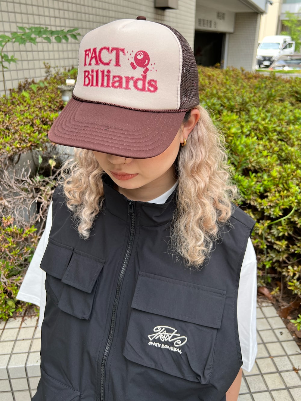 ブラック系のベスト、グレー系のカーゴパンツ、ブラウン系のキャップを着用したレディースの夏コーディネートの3枚目の写真