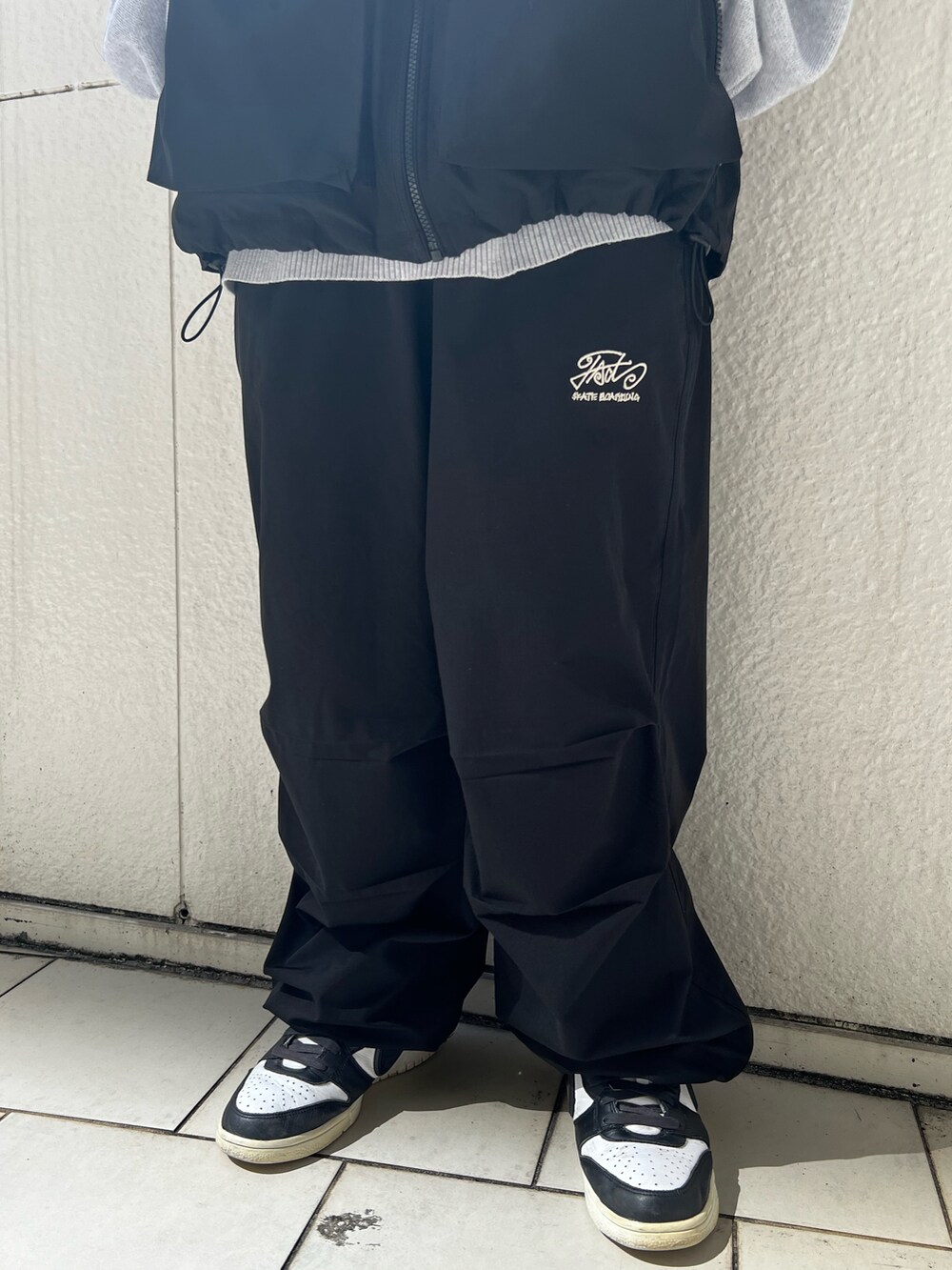 ブラック系のベスト、ブラック系のカーゴパンツ、グレー系のニット/セーターを着用したレディースの秋コーディネートの5枚目の写真